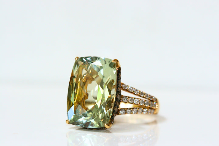 Elongated, cushion cut green quartz ring. Held in place by yellow gold claw prongs. There is subtle, hidden halo of brown diamonds set in black rhodium plated white gold. The shank of the ring is three strands of yellow gold, pave set with white diamonds.