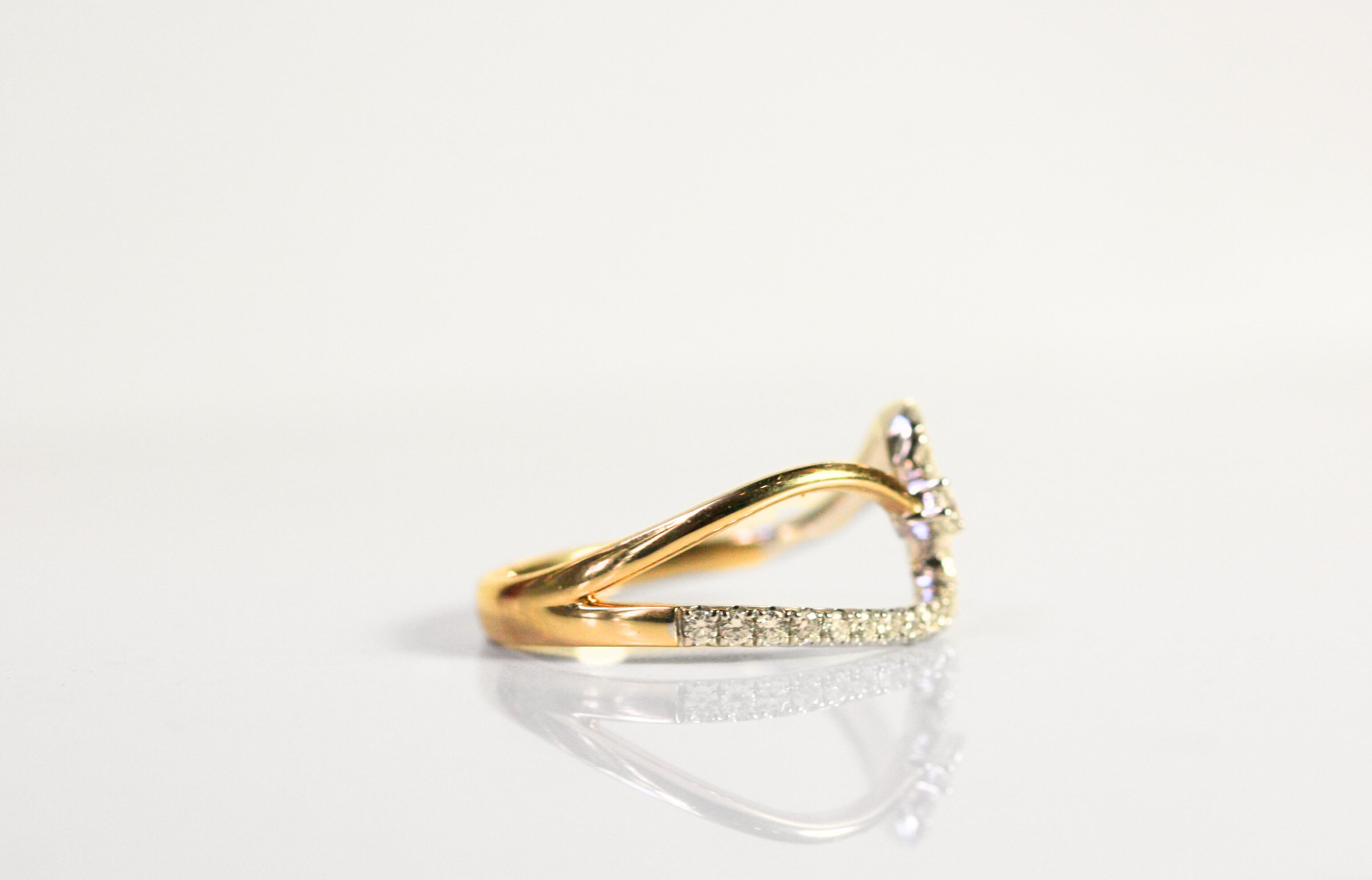 Wave ring. Diamonds all along the wave with a single round diamond floating next to the crest of the wave. Diamonds are set in white gold, while the rest of the ring is yellow gold. Local SF jewelry, San francisco, Luxury, hand made, Bay area, gift for her.