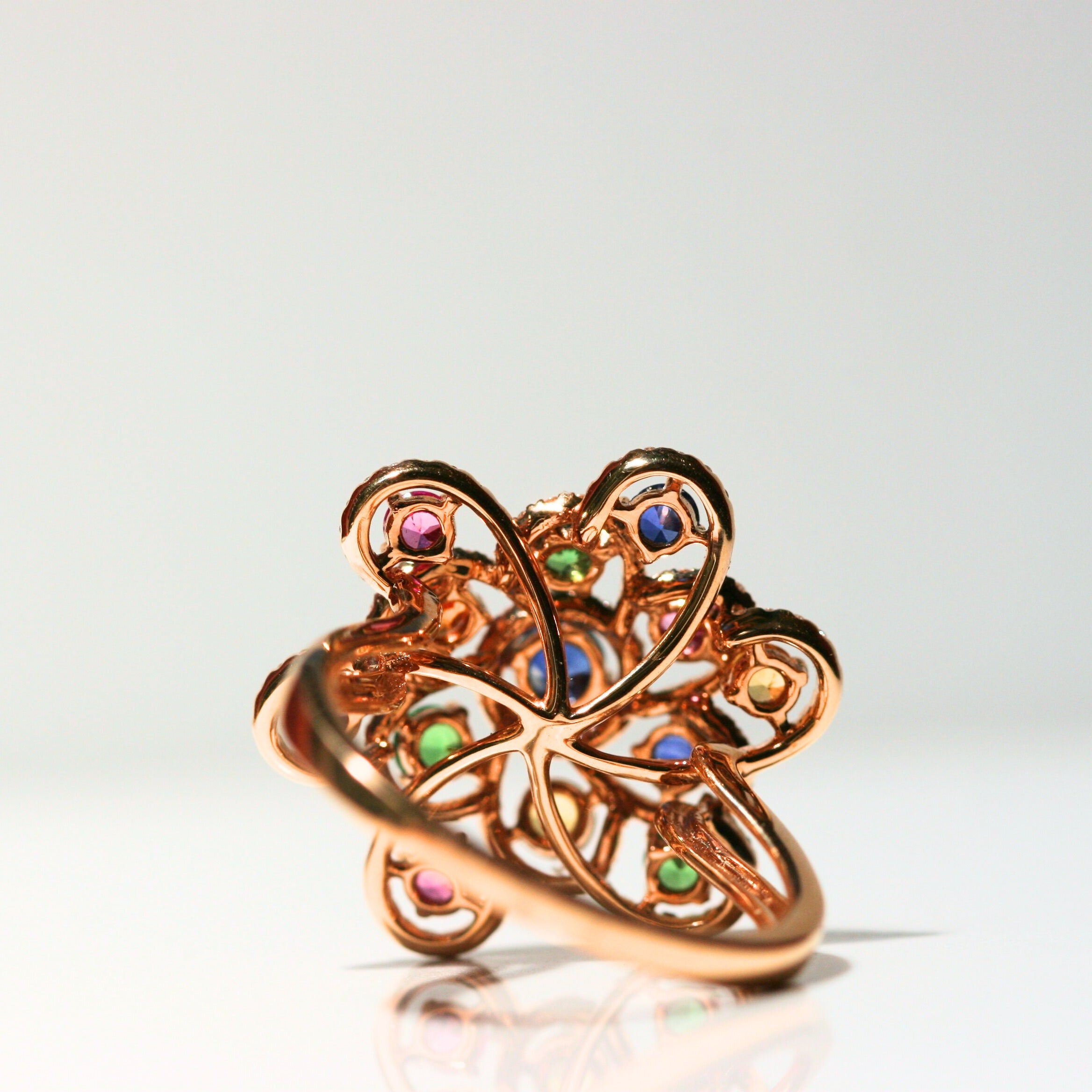 The back of the ring. There is a flat back of whirling rose gold to keep the ring comfortable. The band is made of solid rose gold and is simple. The back of each stone is free of metal, to allow maximum light to shine through.