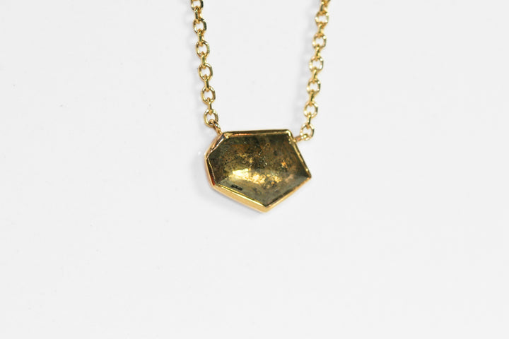 Abstract salt and pepper diamond is bezel set in yellow gold. Pendant, attached to a yellow gold rolo chain. Diamond has interesting inclusions.