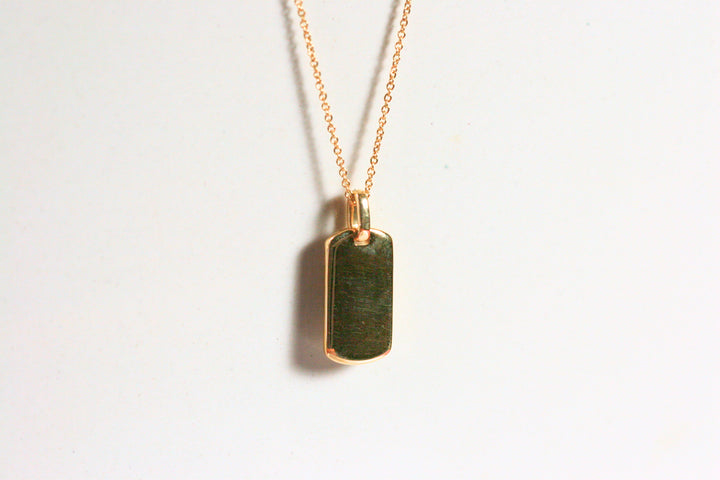 The back of the dog tag is solid gold. This could be engraved or you could set a birthstone in the back. This pendant is reversible.