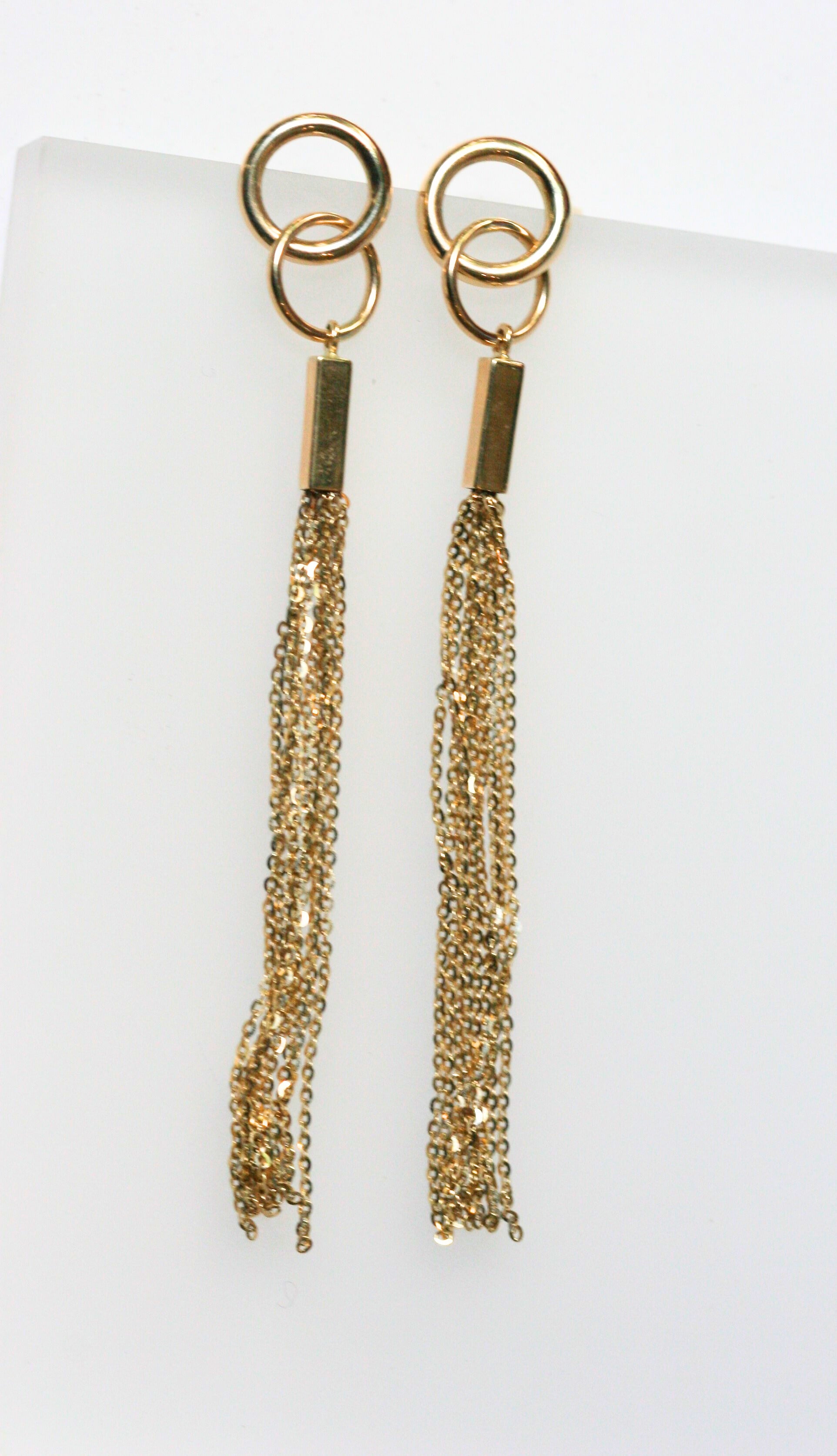 Long gold earrings. Two interlocking circles sit on the ear, while long gold chains dangle off the lower circle. Local SF jewelry, San francisco, Luxury, hand made, Bay area, gift for her