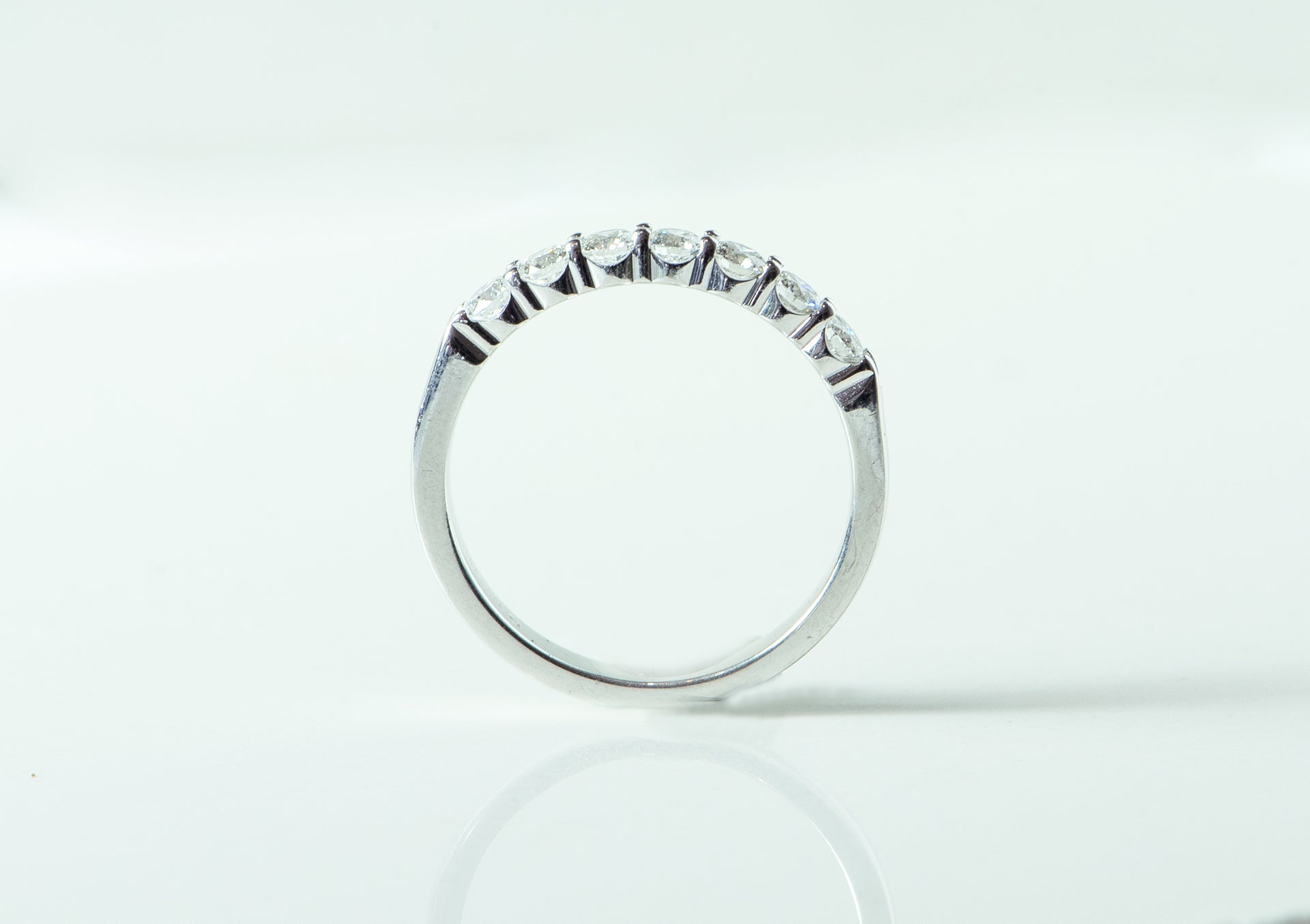 7 stone diamond and white gold ring. wedding band. shared prong set.