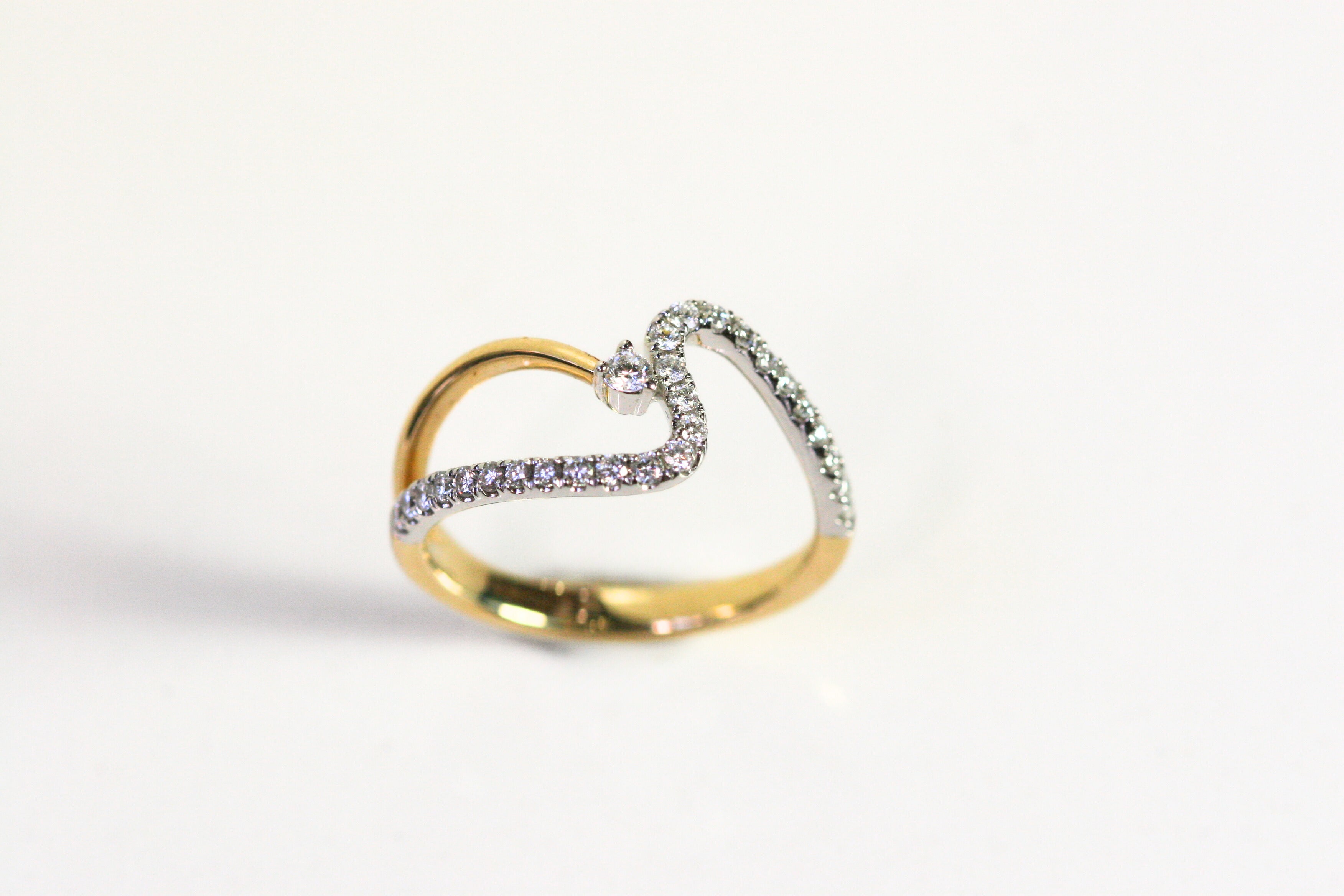 Wave ring. Diamonds all along the wave with a single round diamond floating next to the crest of the wave. Diamonds are set in white gold, while the rest of the ring is yellow gold. Local SF jewelry, San francisco, Luxury, hand made, Bay area, gift for her.