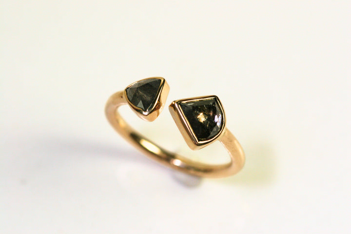 Unique ring. Two triangular diamonds are bezel set and the band is fully rounded. They meet in the middle with a slight space between the two.