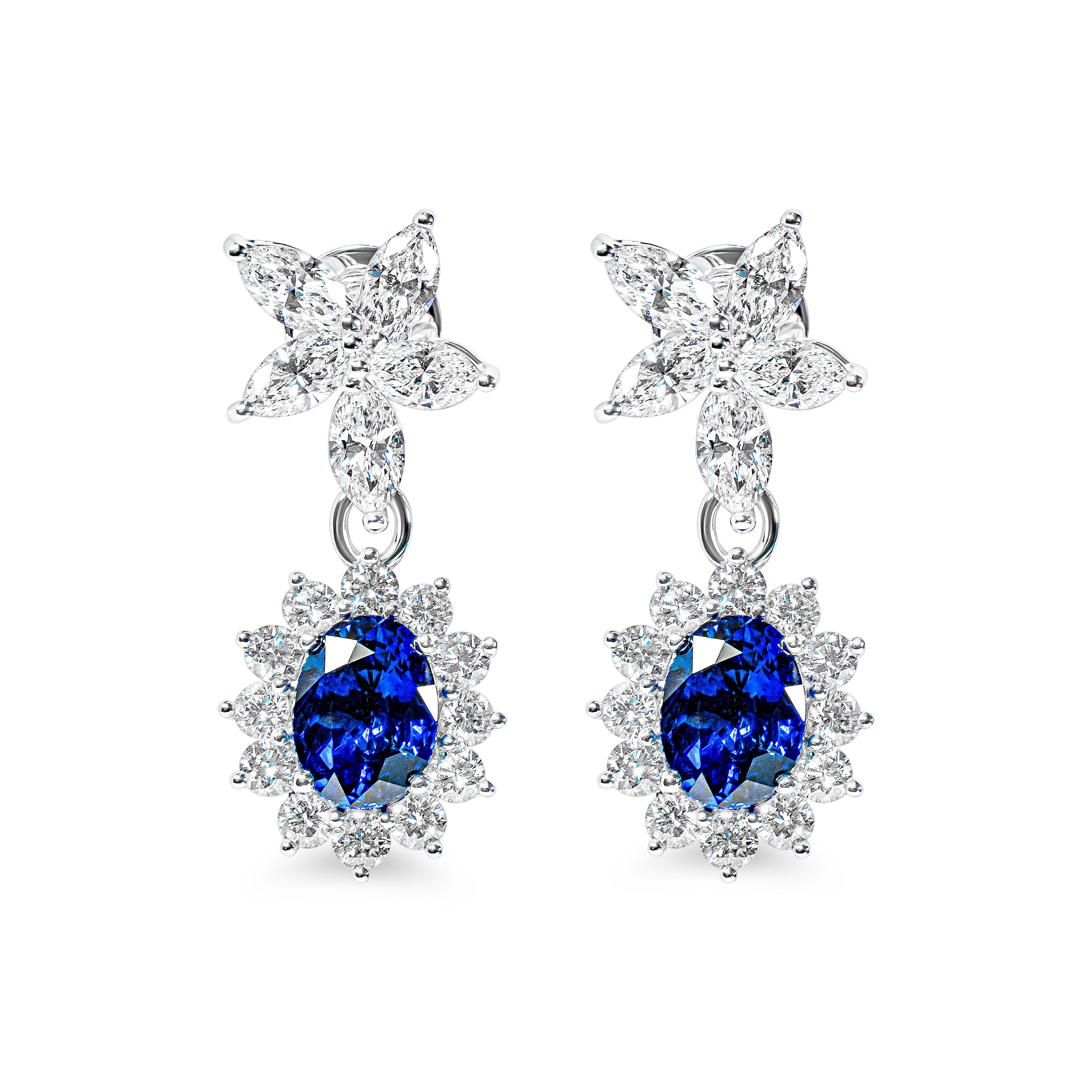 Pair of earrings with blue sapphires and flower-shaped tops on a white background