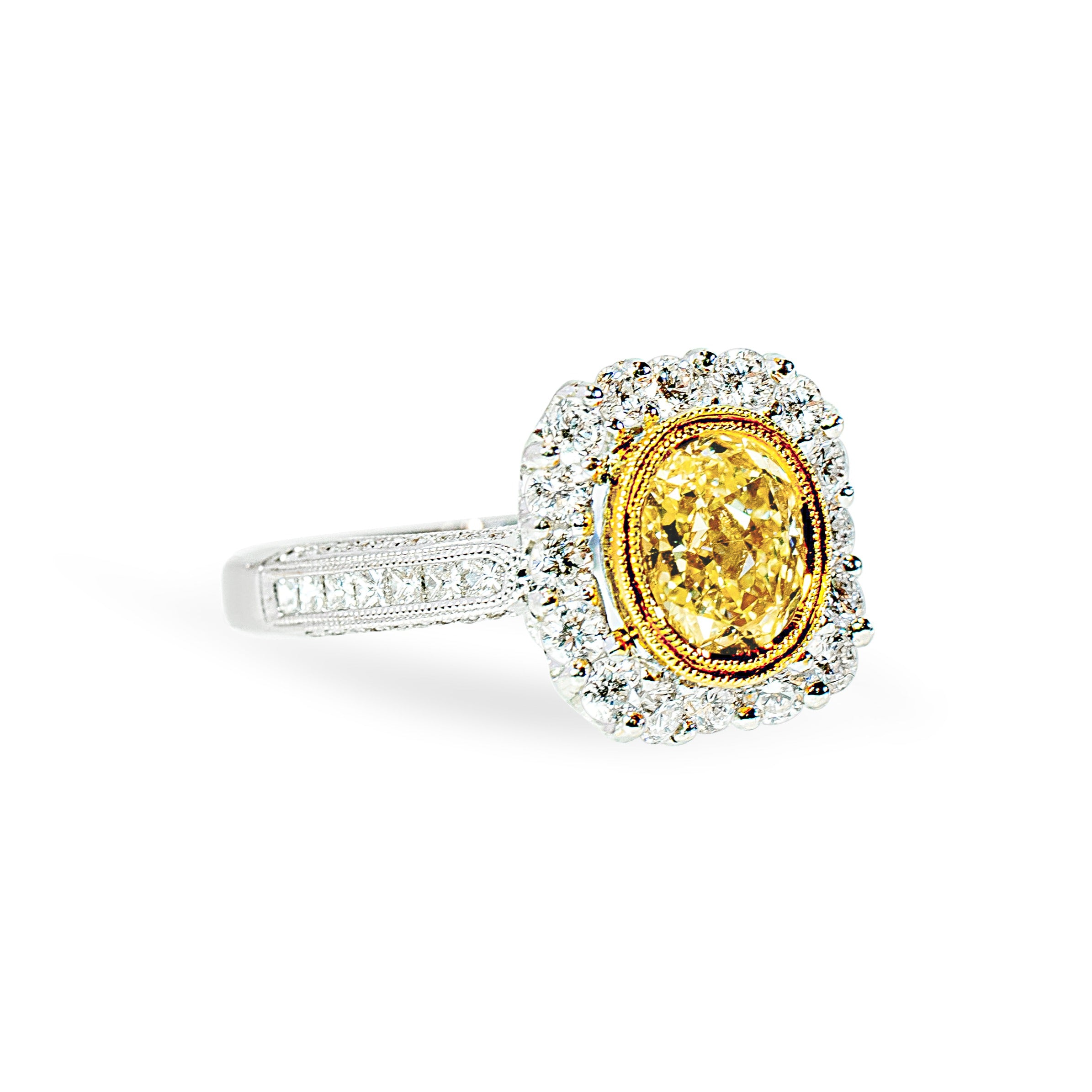 Ring with a yellow diamond and diamond halo on a white background