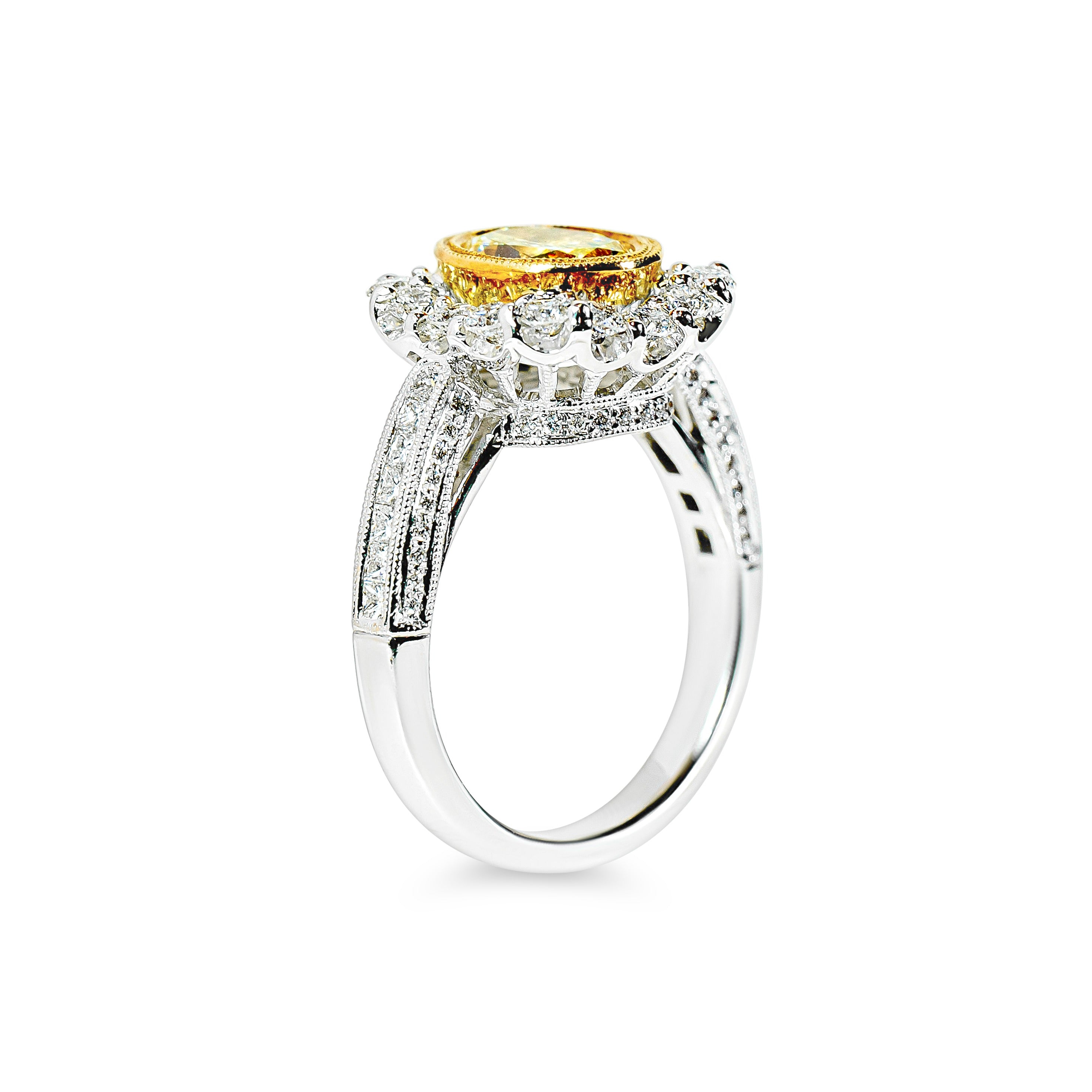 Ring with a yellow diamond and diamond halo on a white background