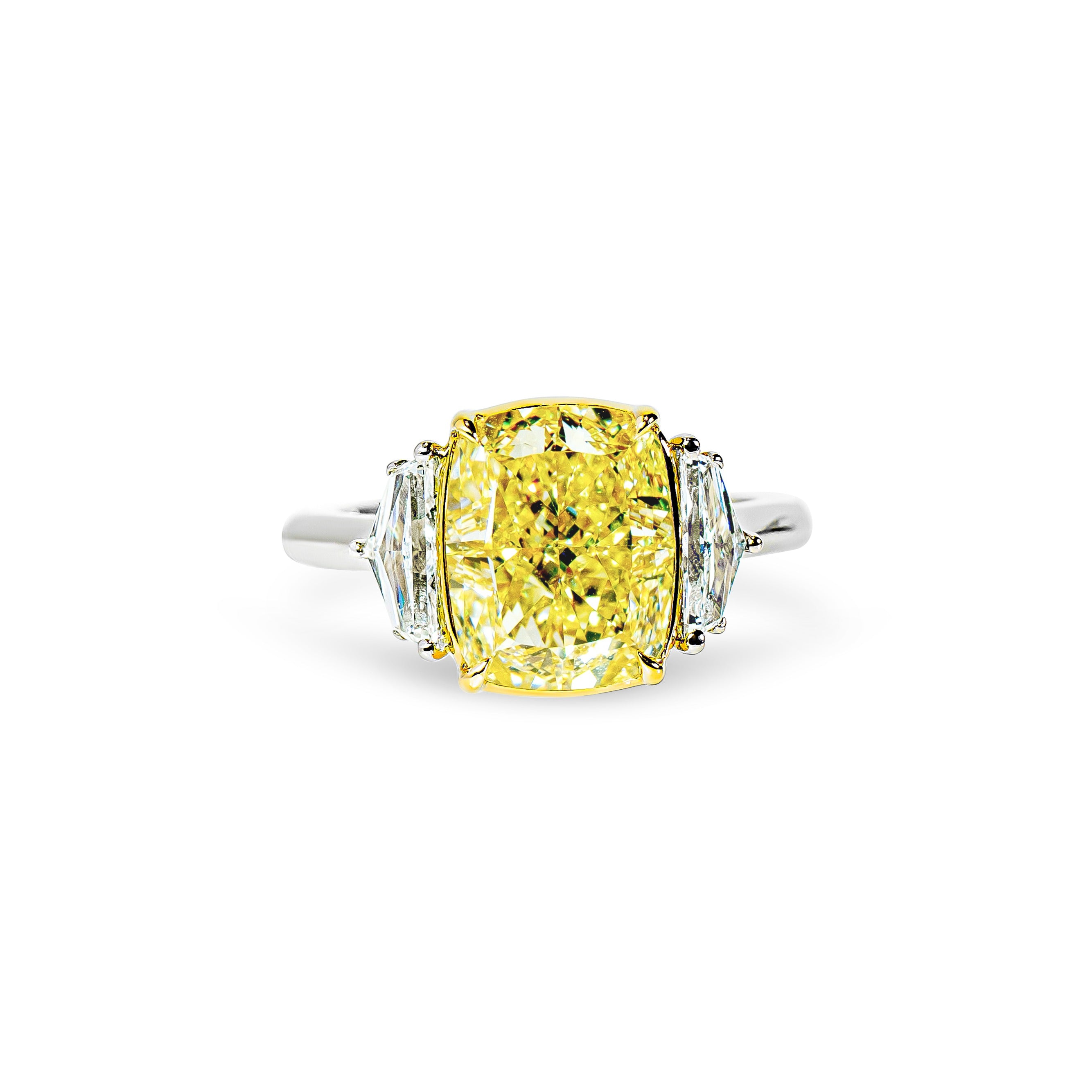 Ring with a yellow diamond and two smaller clear cadillac diamonds on a white background
