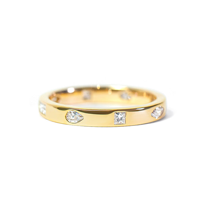 Gold ring with embedded with mix-shaped diamonds on a white background