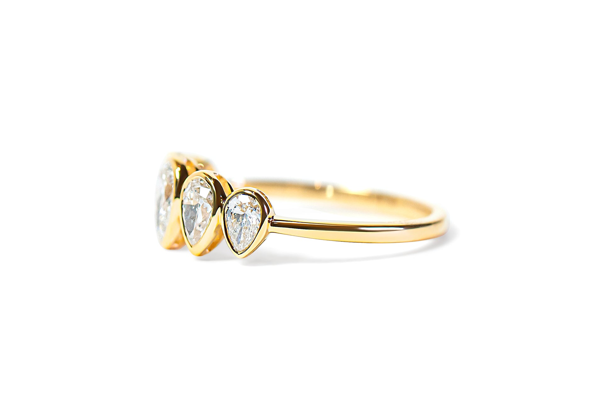 Gold ring with pear-shaped diamonds on a white background