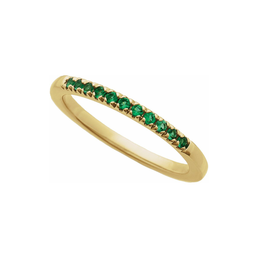 Gold ring with emeralds on a white background