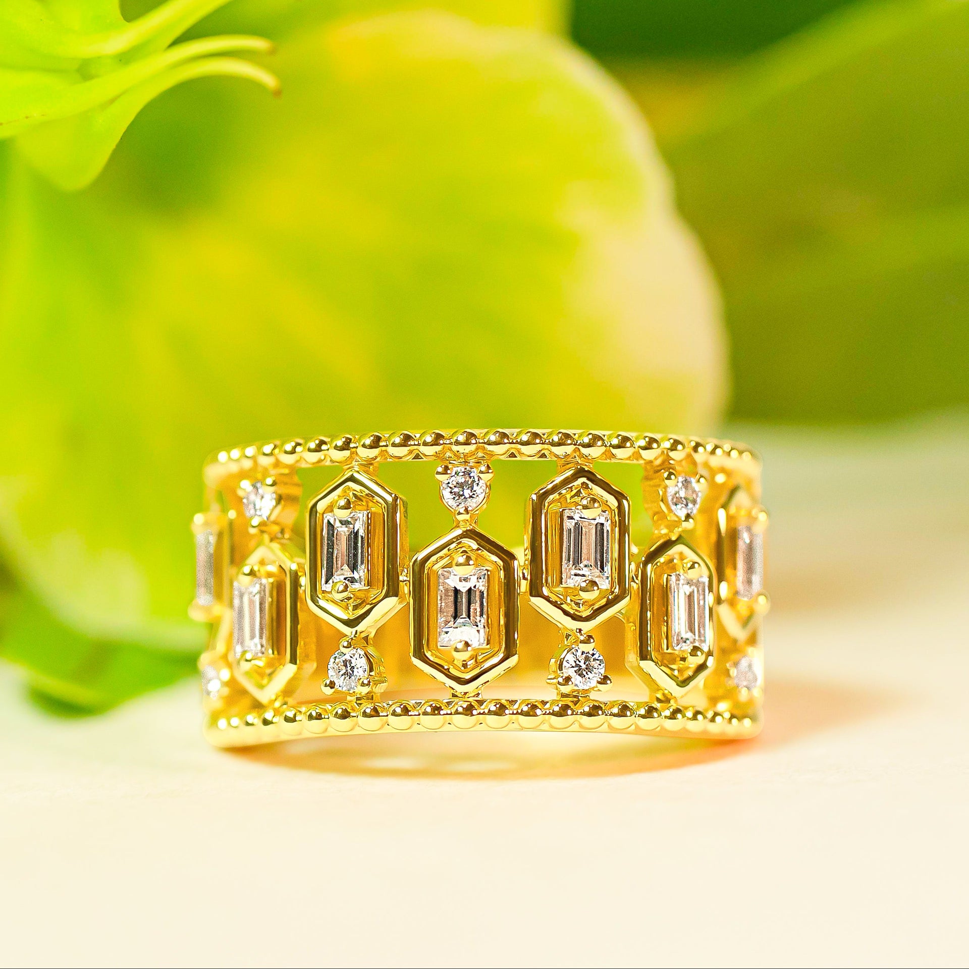 Gold ring with diamond accents on a green leaf background