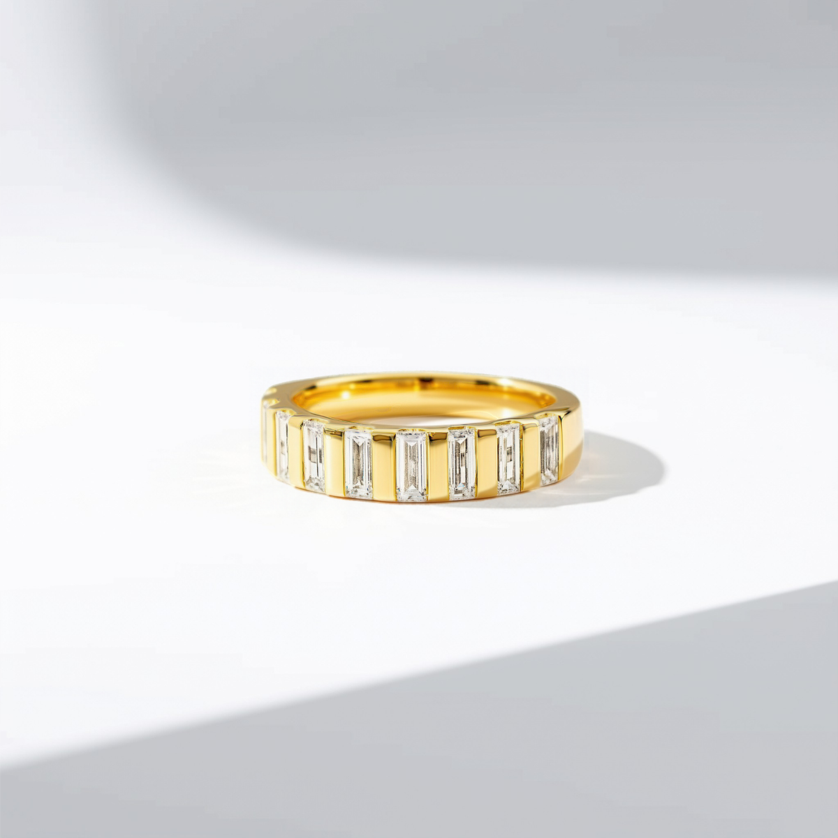 A gold band ring featuring a row of vertically channel-set baguette-cut diamonds. 