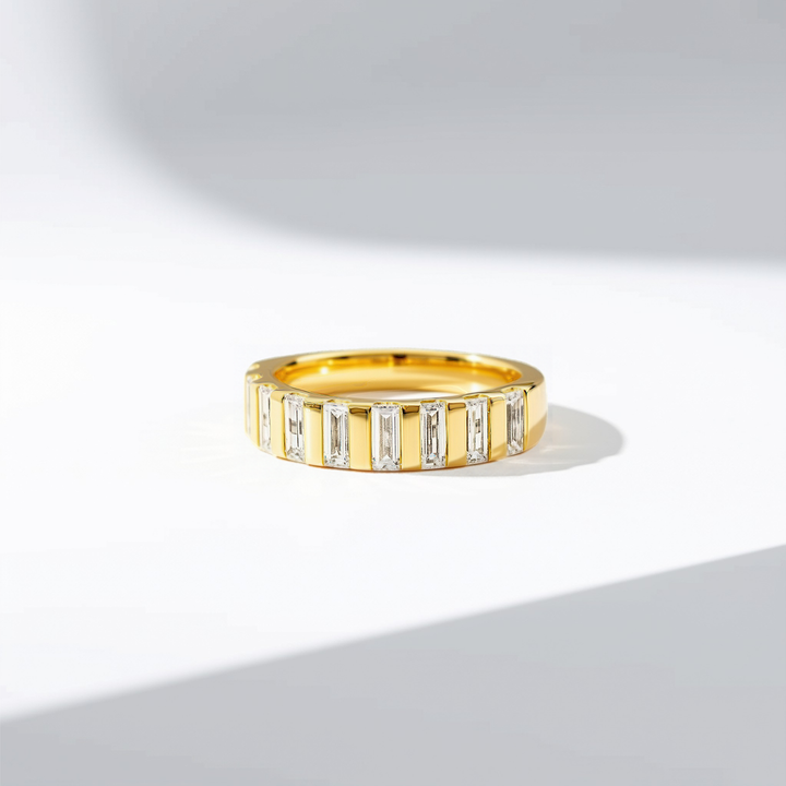 A gold band ring featuring a row of vertically channel-set baguette-cut diamonds. 