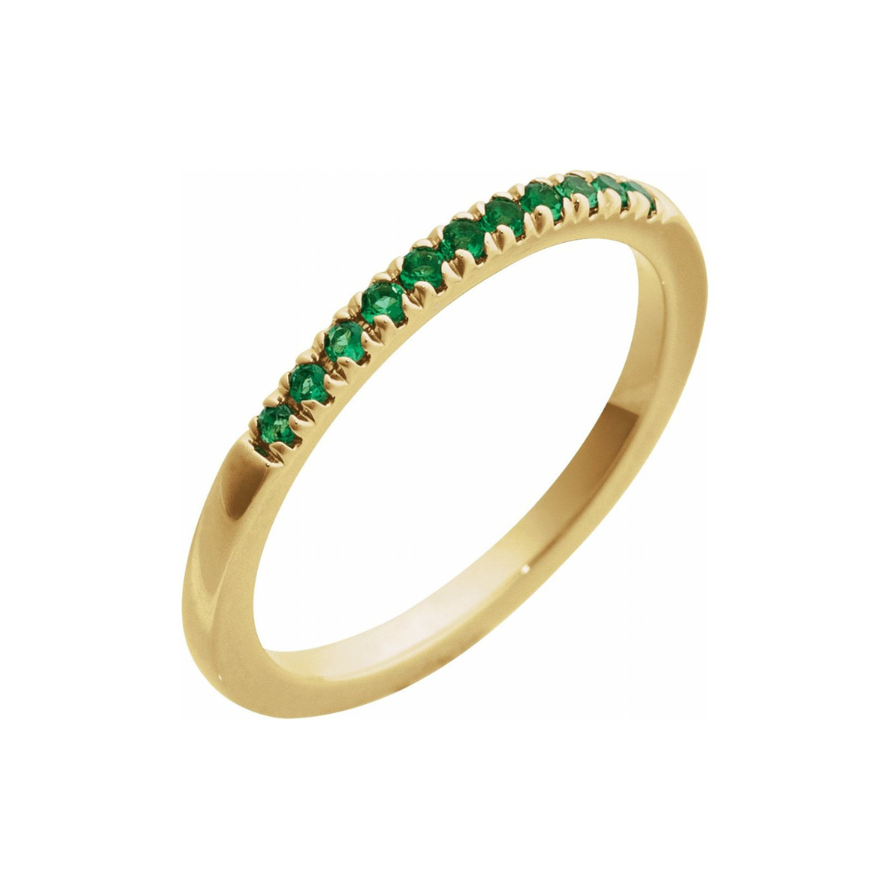 Gold ring with emeralds on a white background