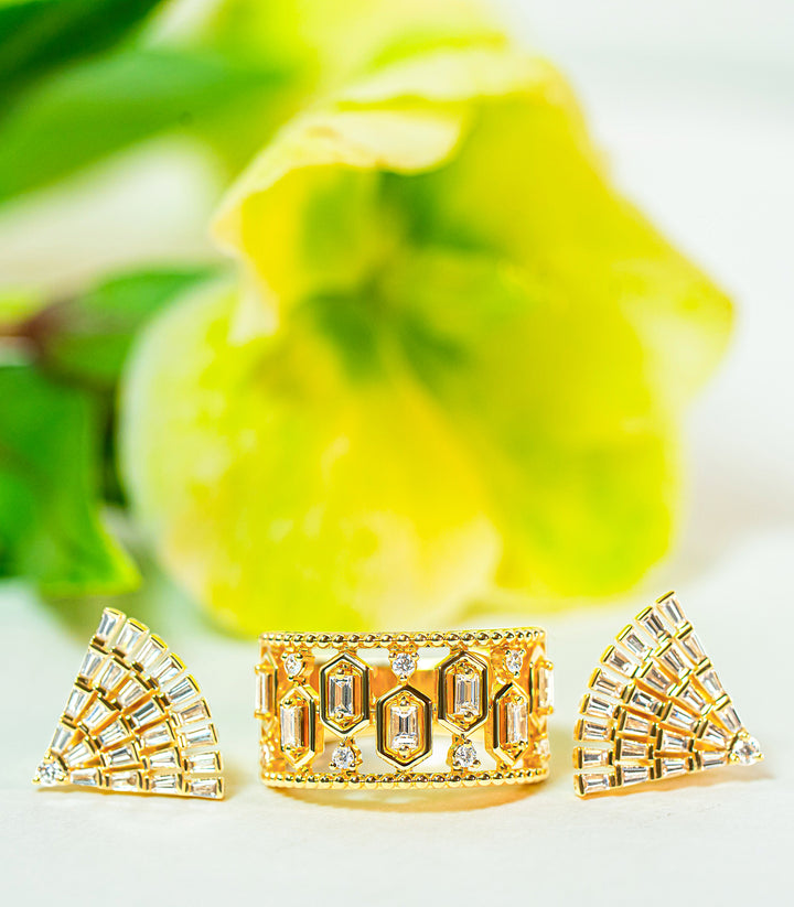 Gold ring and fan-shaped earrings with diamonds on a light background