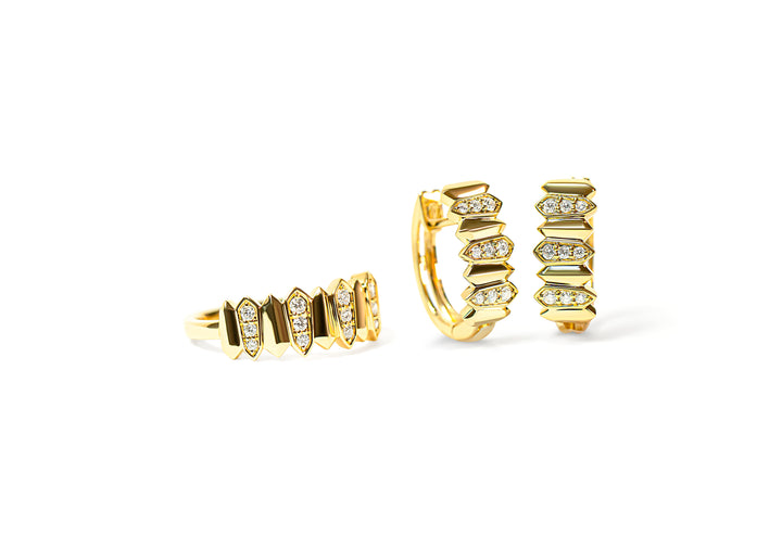 Gold hoop earrings and a gold ring with embedded diamonds on a white background