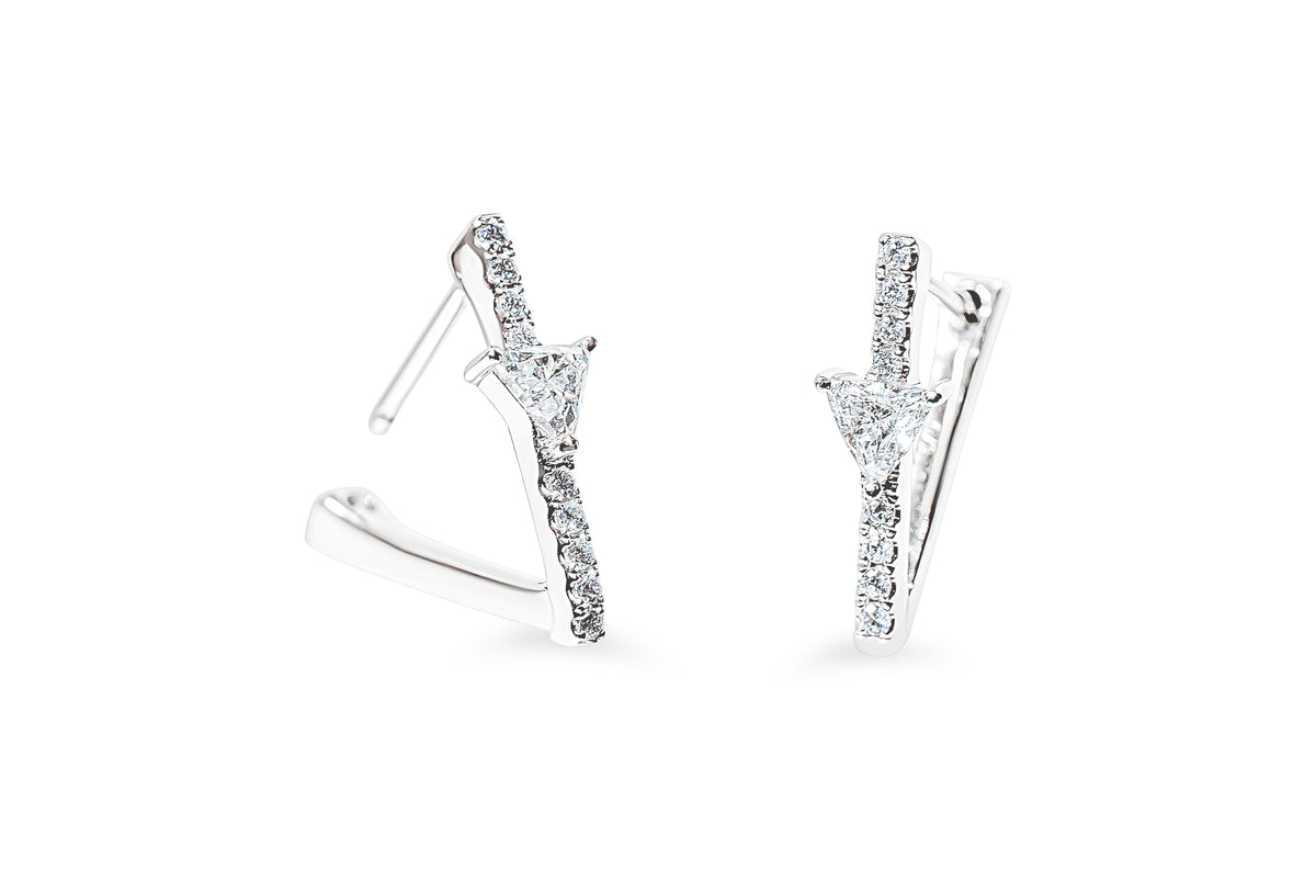 A pair of white-gold geometric hoop earrings with triangular diamonds and pavé round diamonds, shown on a clean white background.