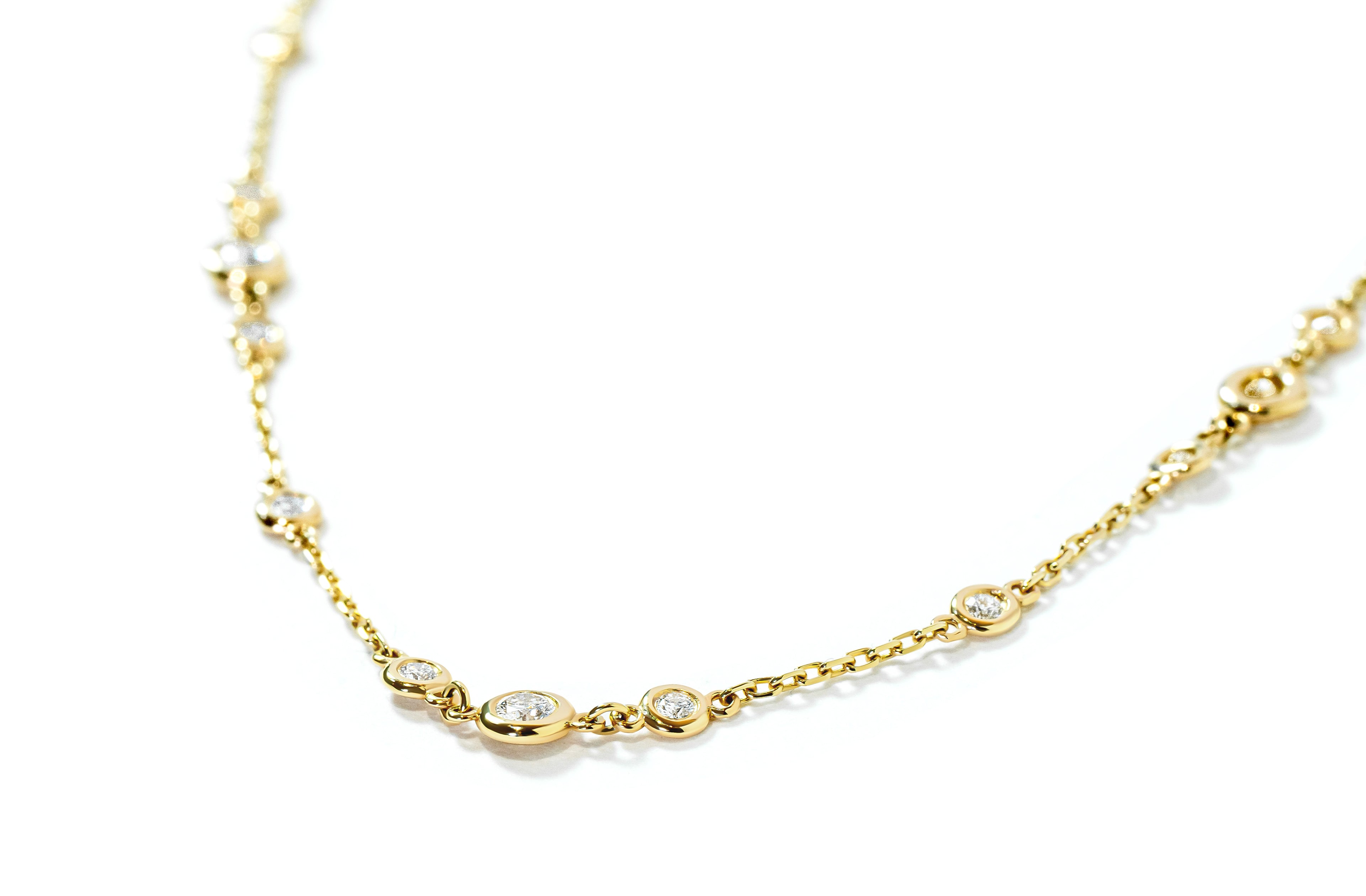 Gold necklace with small bezel-set diamonds on a white background