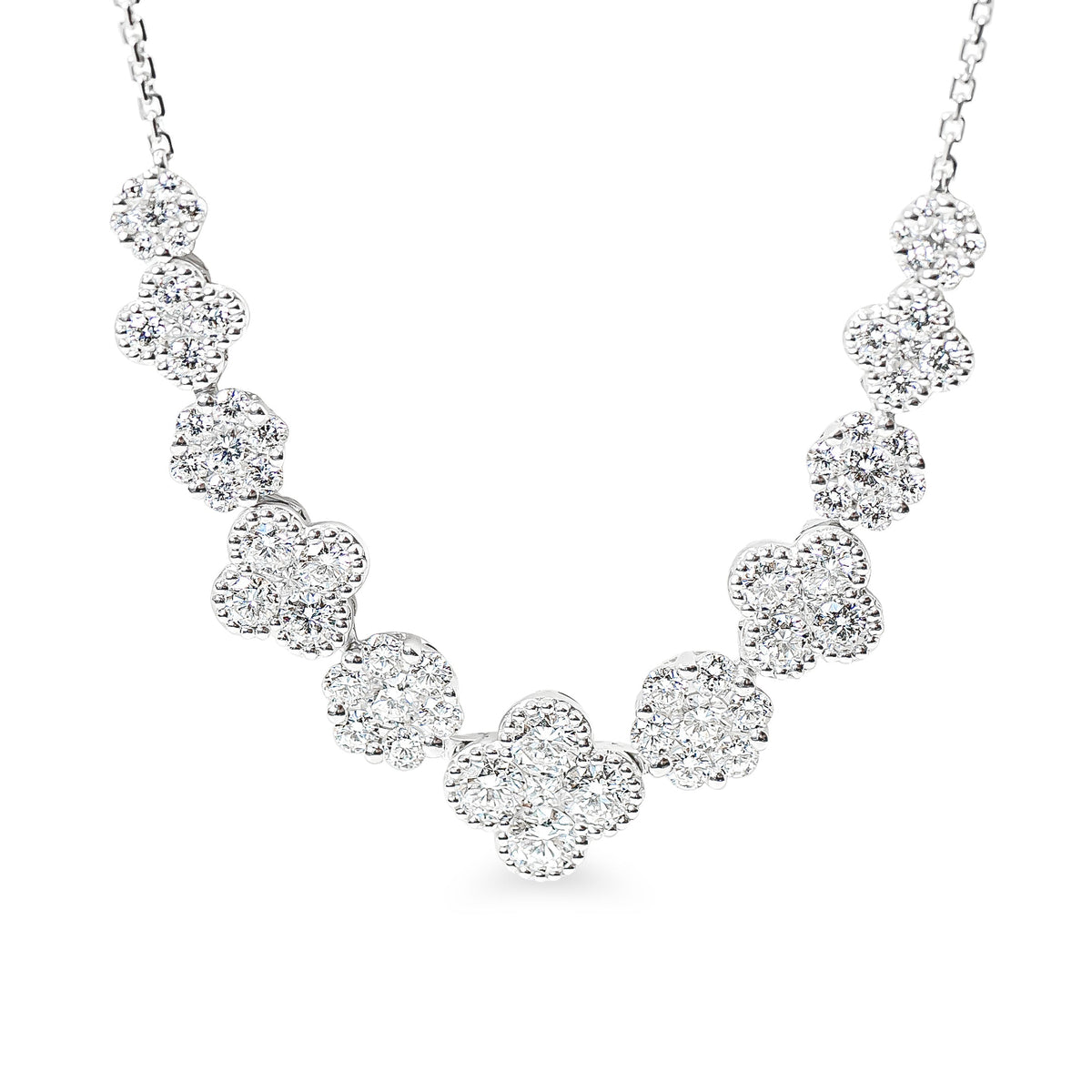 A silver-toned necklace featuring a series of round floral or clover-shaped clusters of clear pavé white diamonds, suspended from a delicate chain against a plain white background.