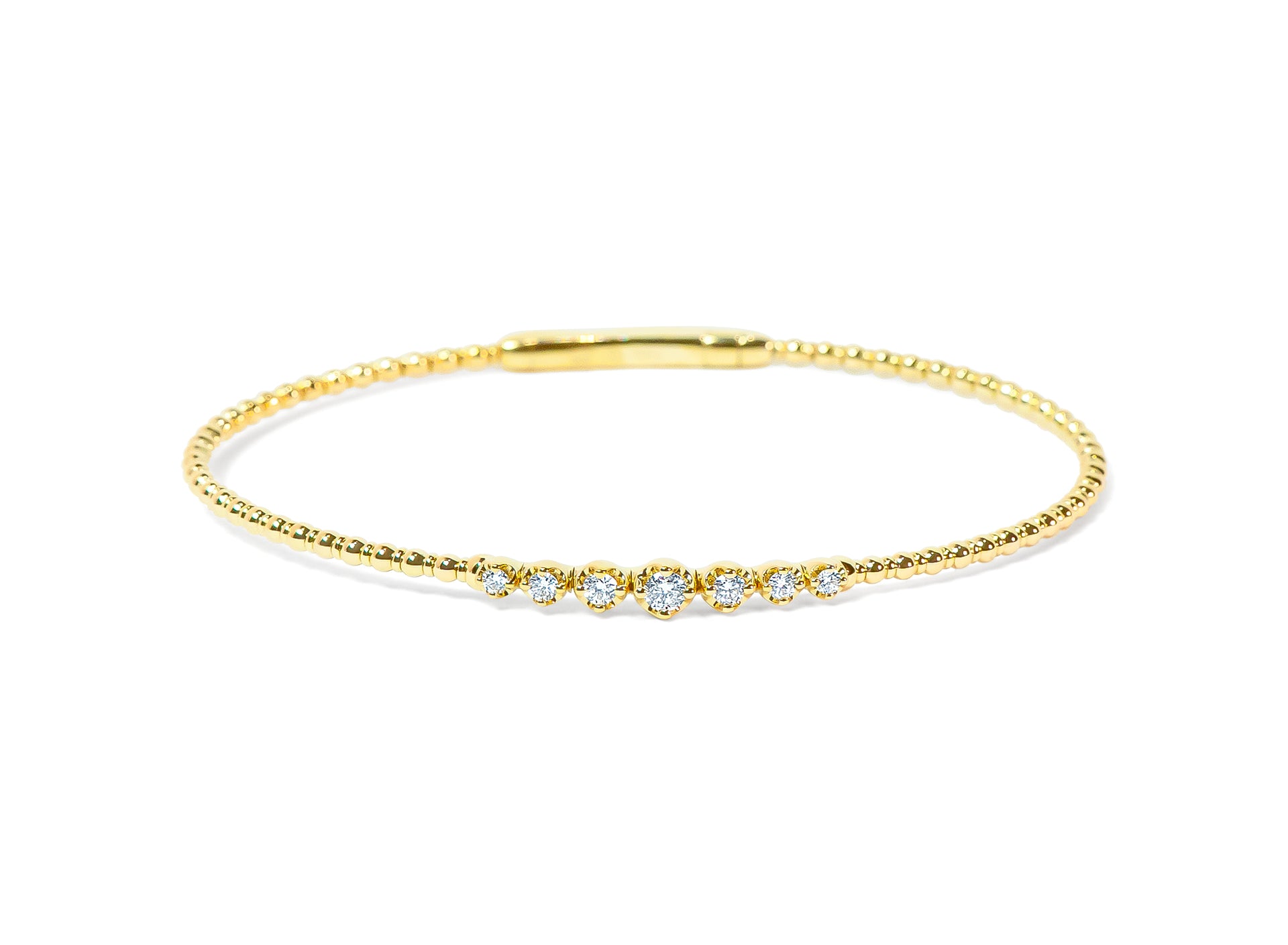 Gold bangle with small diamonds on a white background