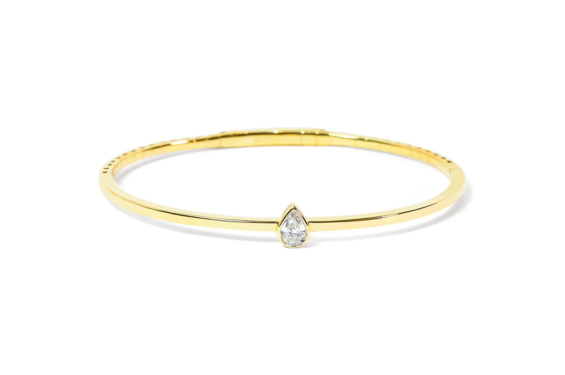 Gold bracelet with a teardrop-shaped or pear-shaped diamond on a white background