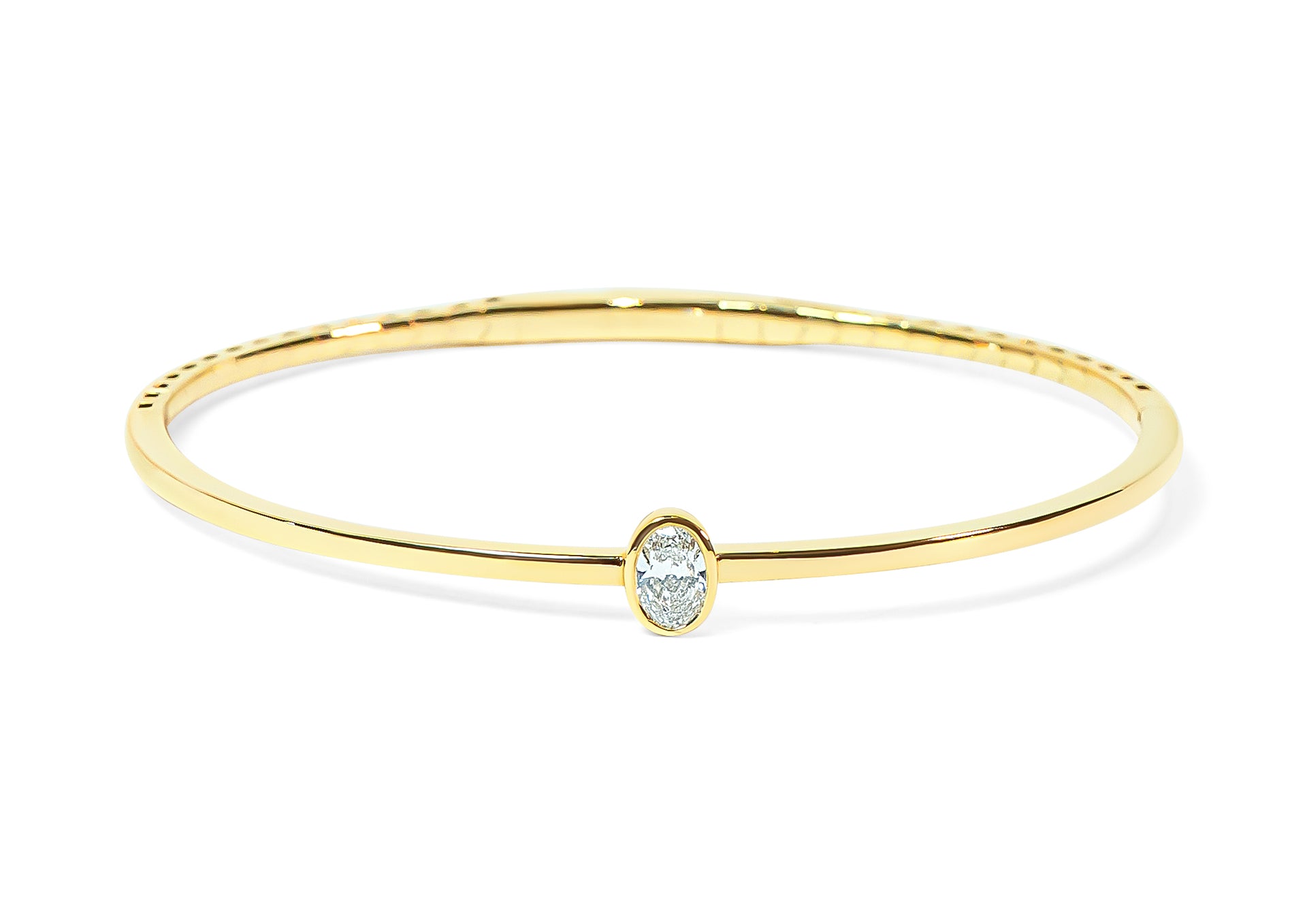 Gold bangle with an oval-shaped diamond on a white background