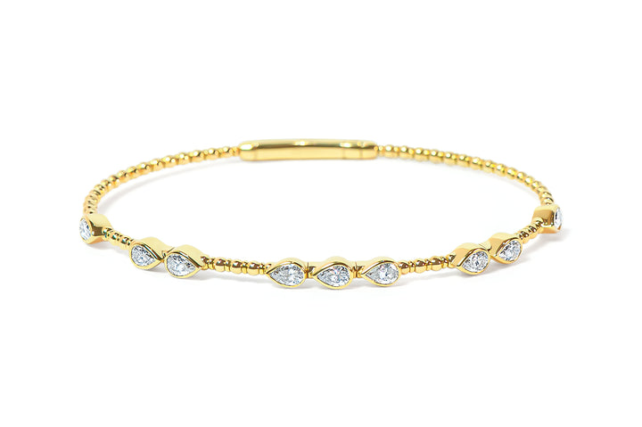 Gold bangle with teardrop or pear-shaped diamonds on a white background