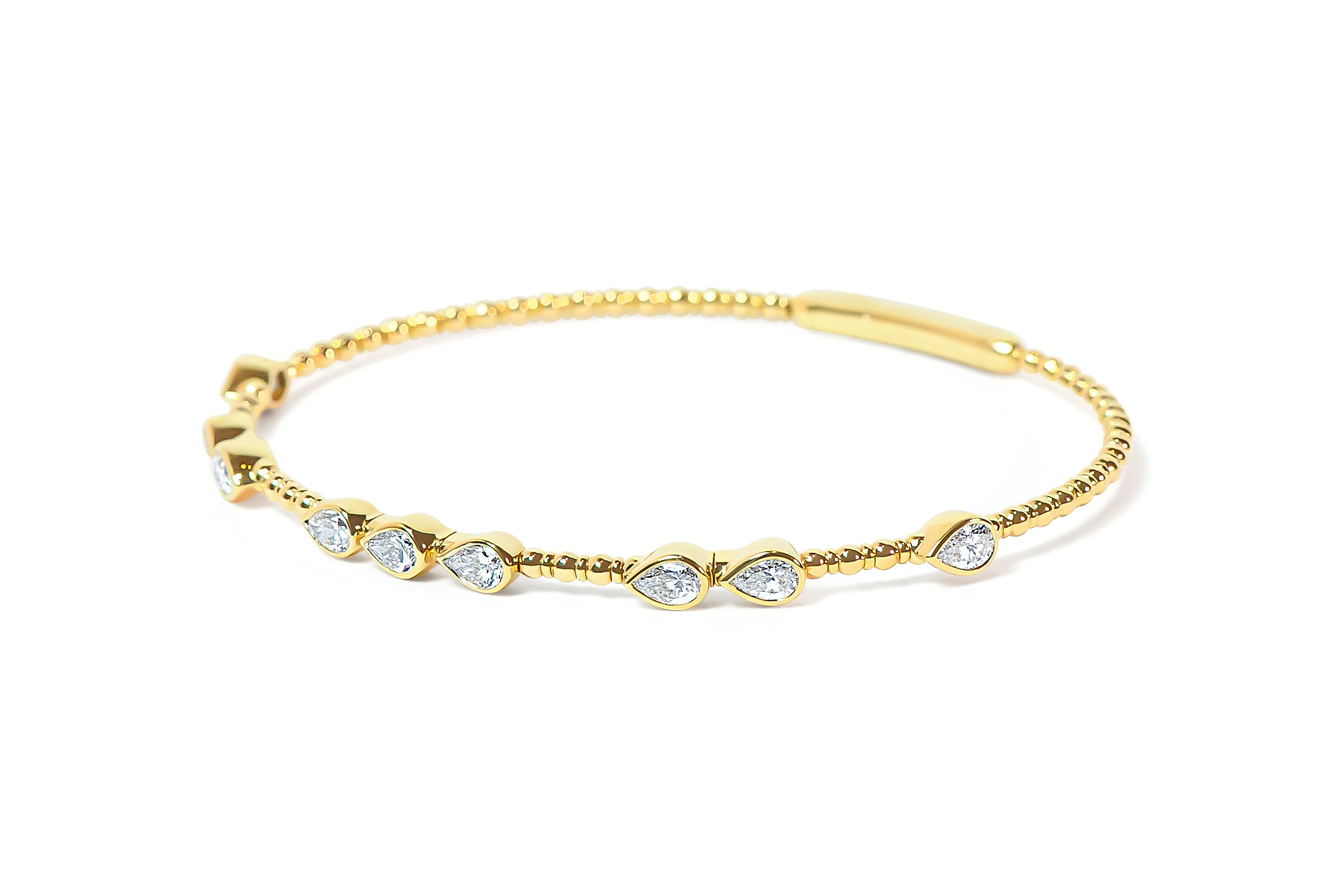 Gold bangle with teardrop or pear-shaped diamonds on a white background