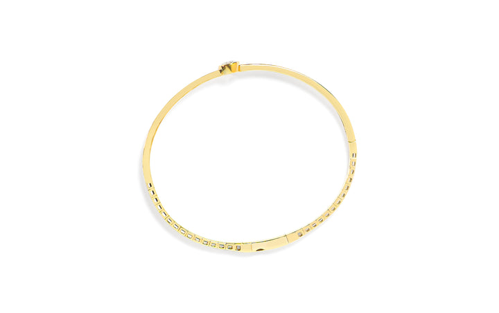 Top view of a gold bangle with a round diamond on a white background