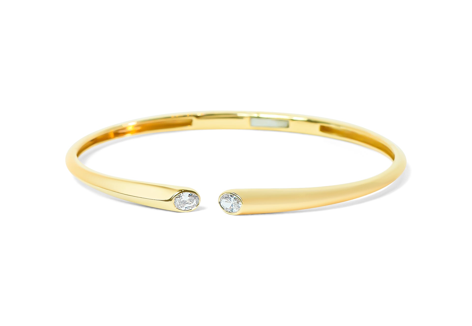 Gold bangle with two oval diamonds on a white background