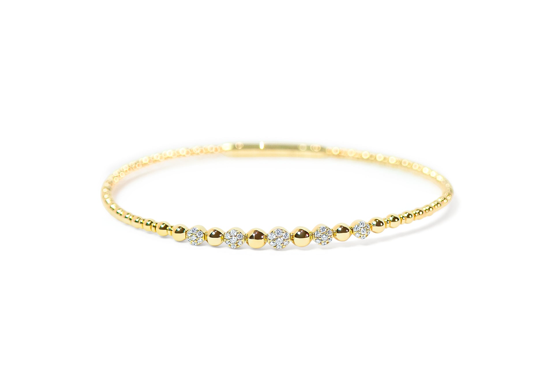 Gold bangle with pave diamonds and beaded-texture on a white background