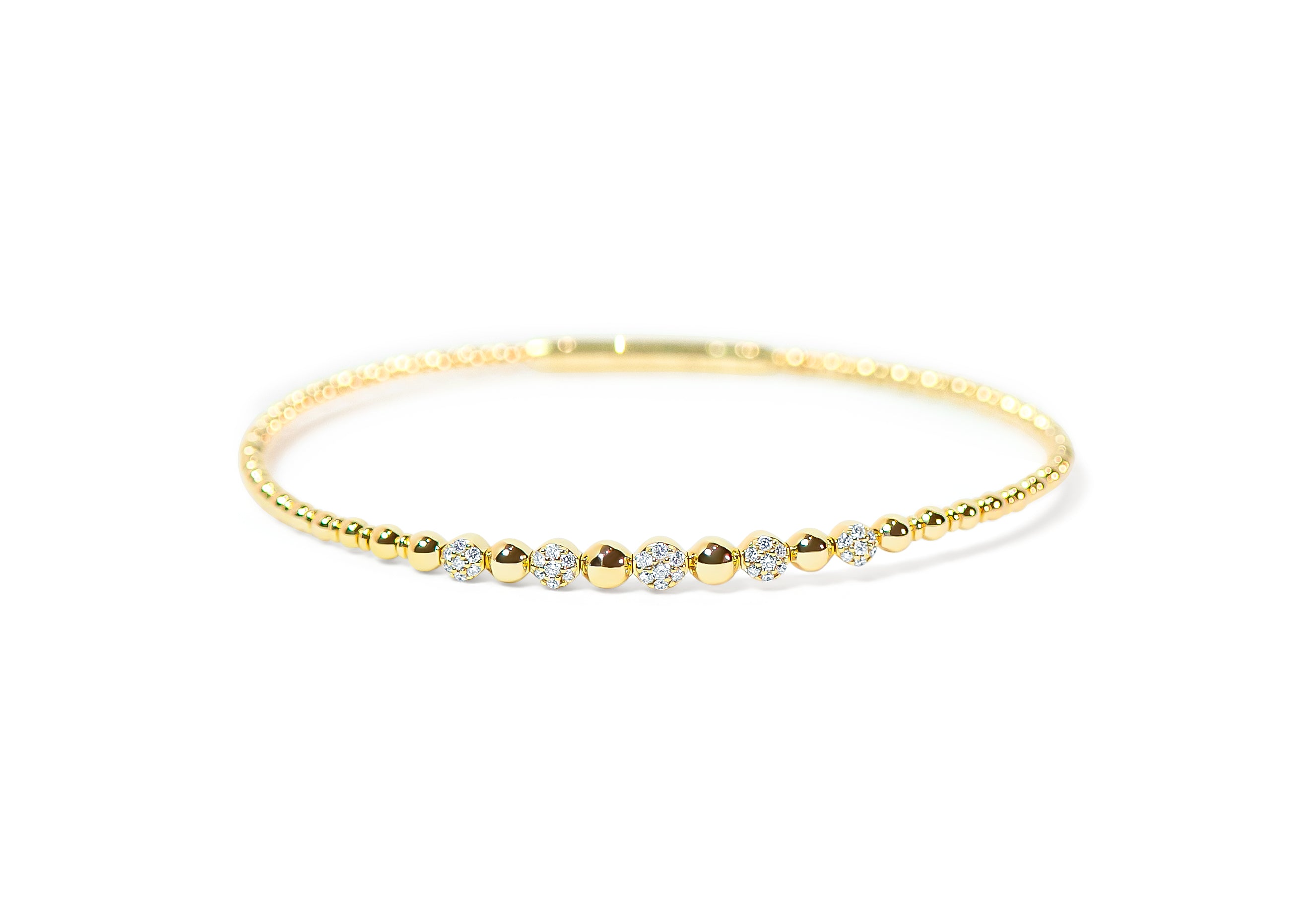 Gold bangle with pave diamonds and beaded-texture on a white background