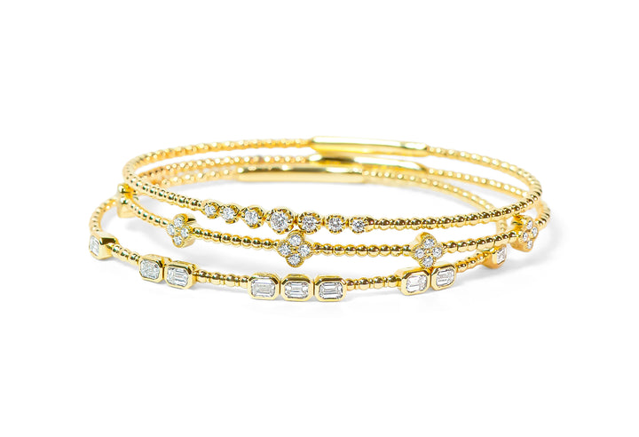 Set of gold bracelets with diamonds on a white background