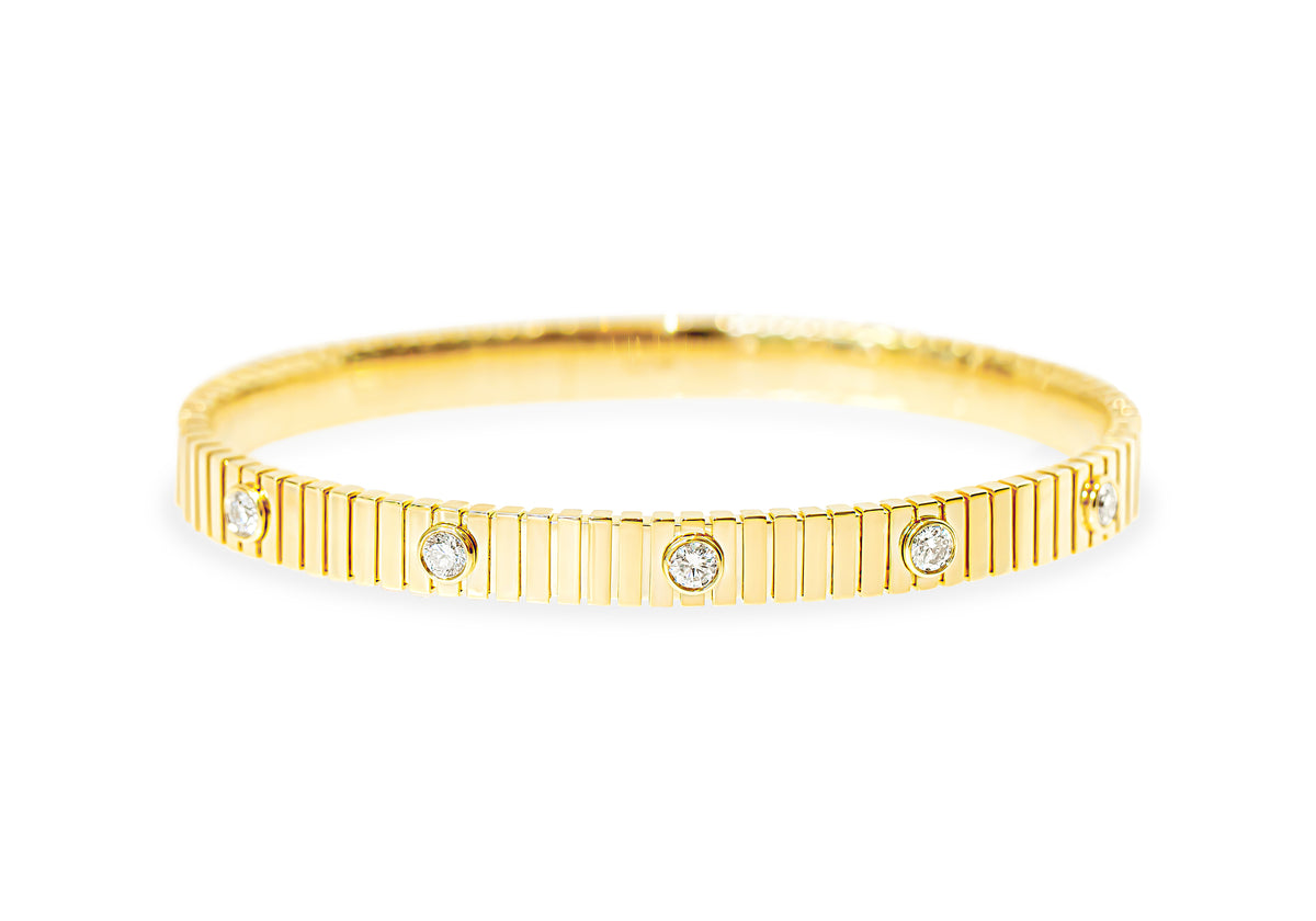 A yellow gold bangle bracelet featuring a textured, fluted outer band and five evenly spaced bezel round diamonds, shown on a plain white background.