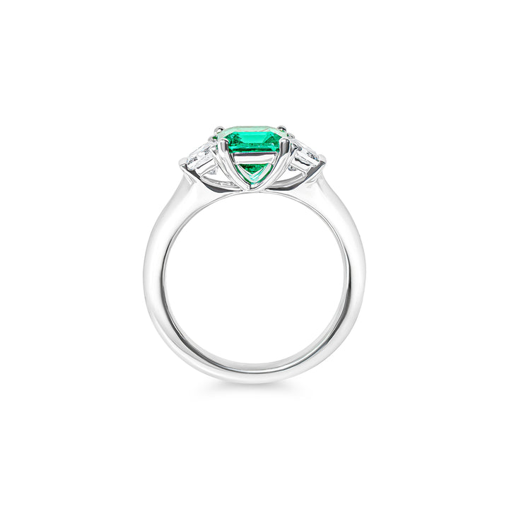 Platinum ring with a green emerald and diamonds on a white background