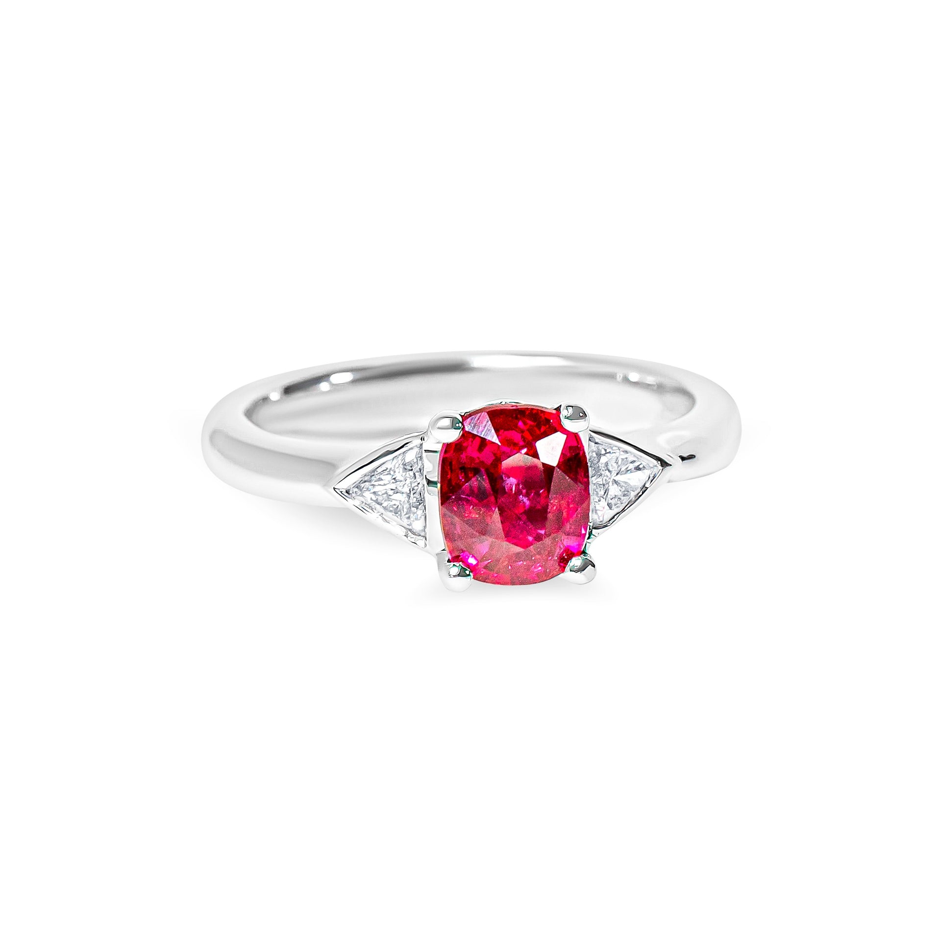 Platinum ring with a red ruby and two trillion diamonds on a white background