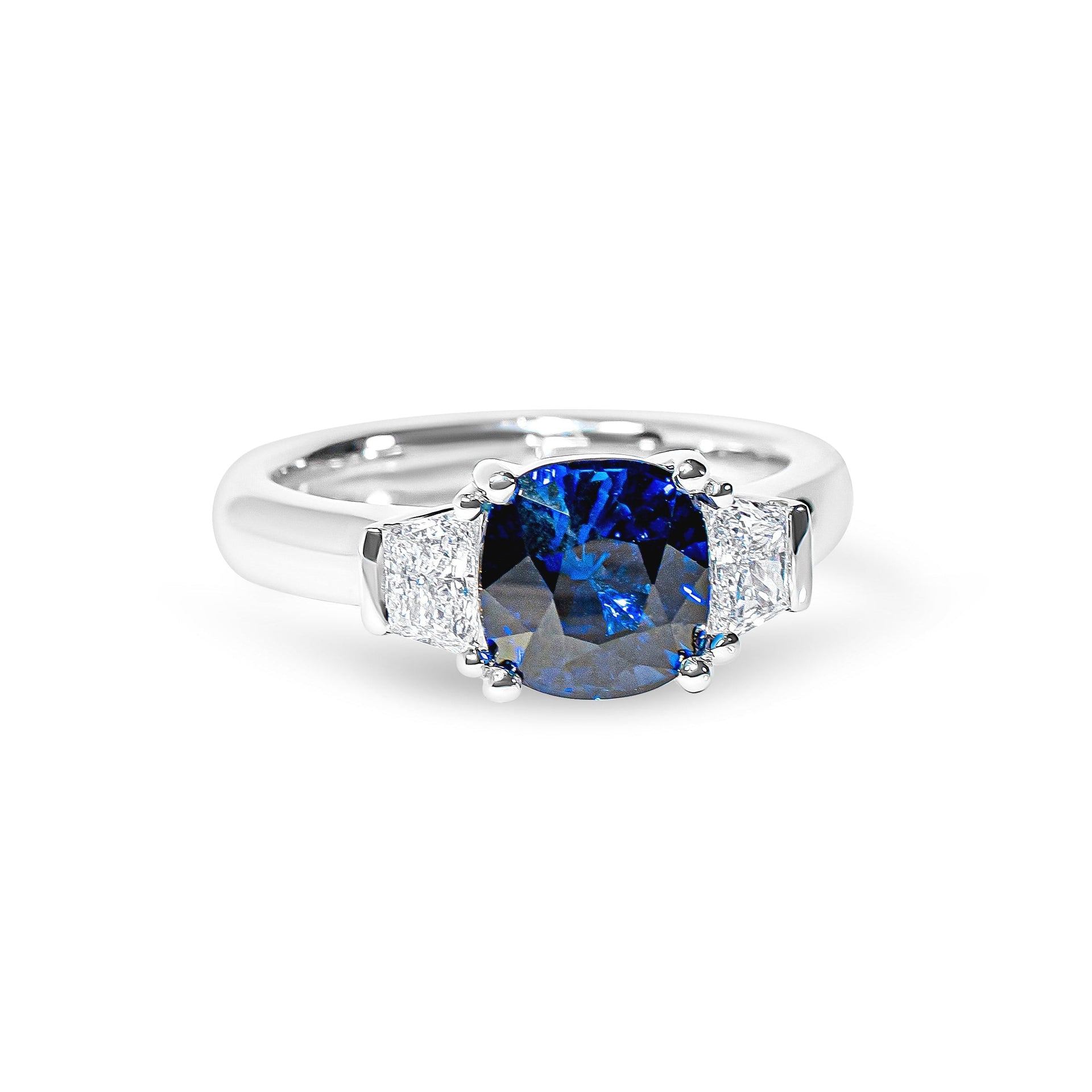 Platinum ring with a blue sapphire and diamonds on a white background