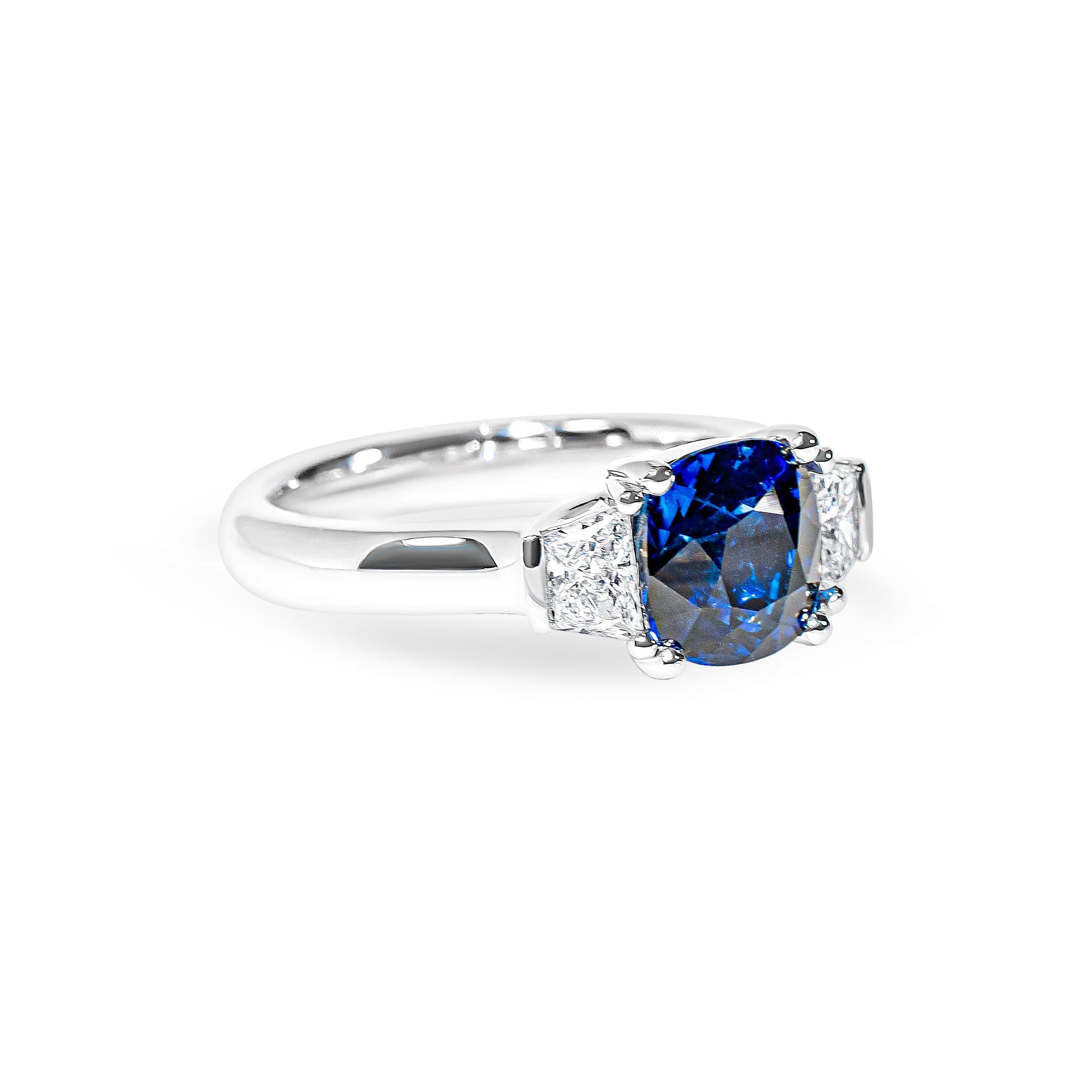 Platinum ring with a blue sapphire and diamonds on a white background