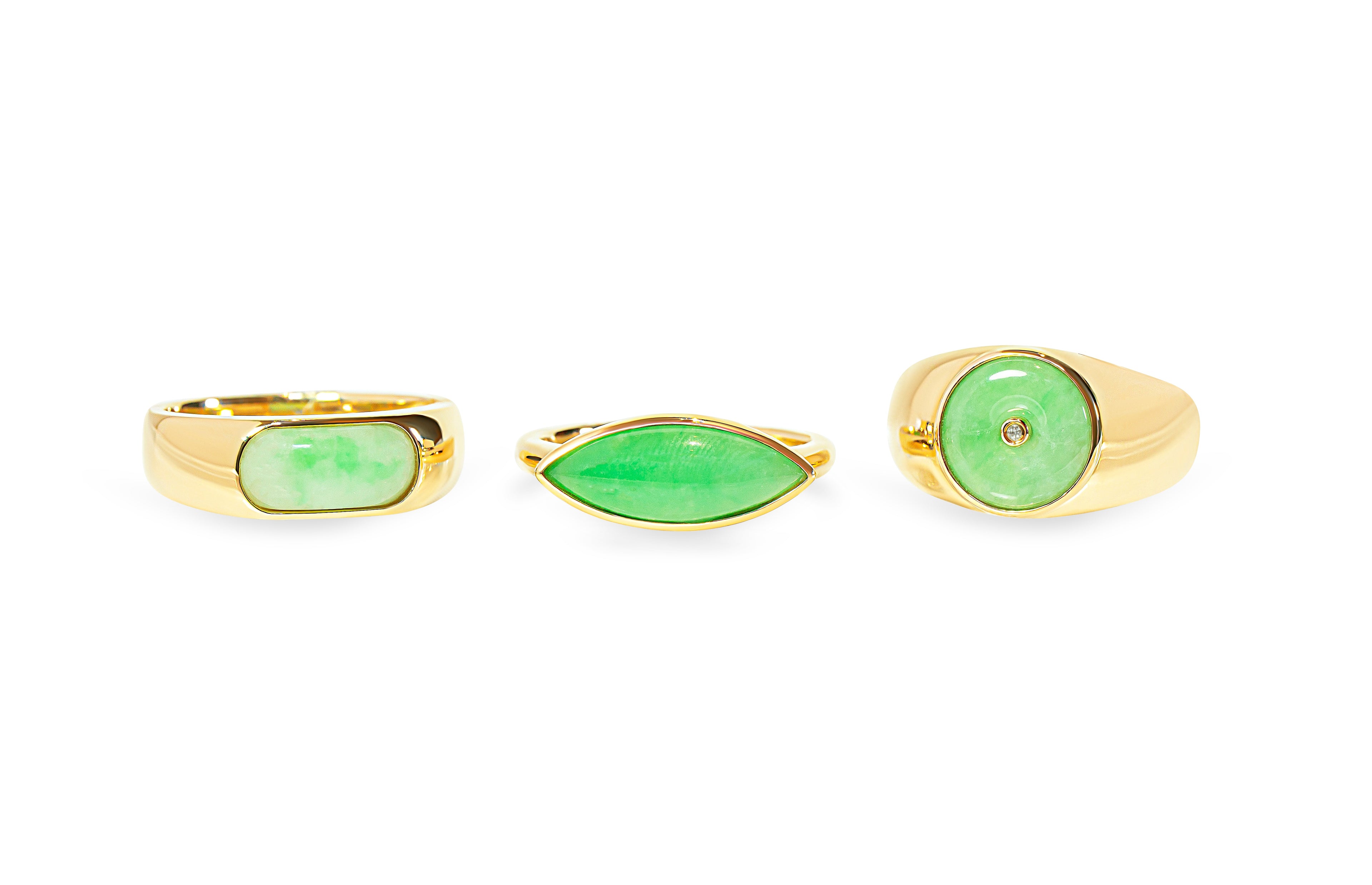 Three green jade rings with gold bands on a white background