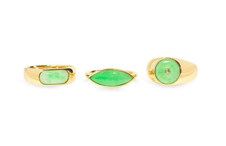 Three green jade rings with gold bands on a white background
