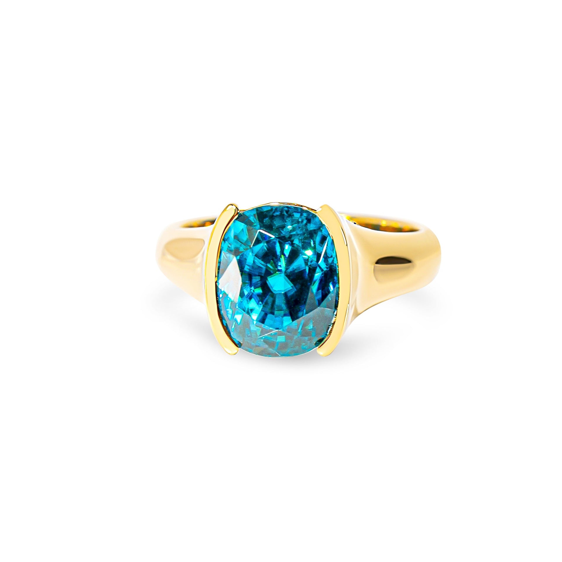 Gold ring with a blue zircon on a white background
