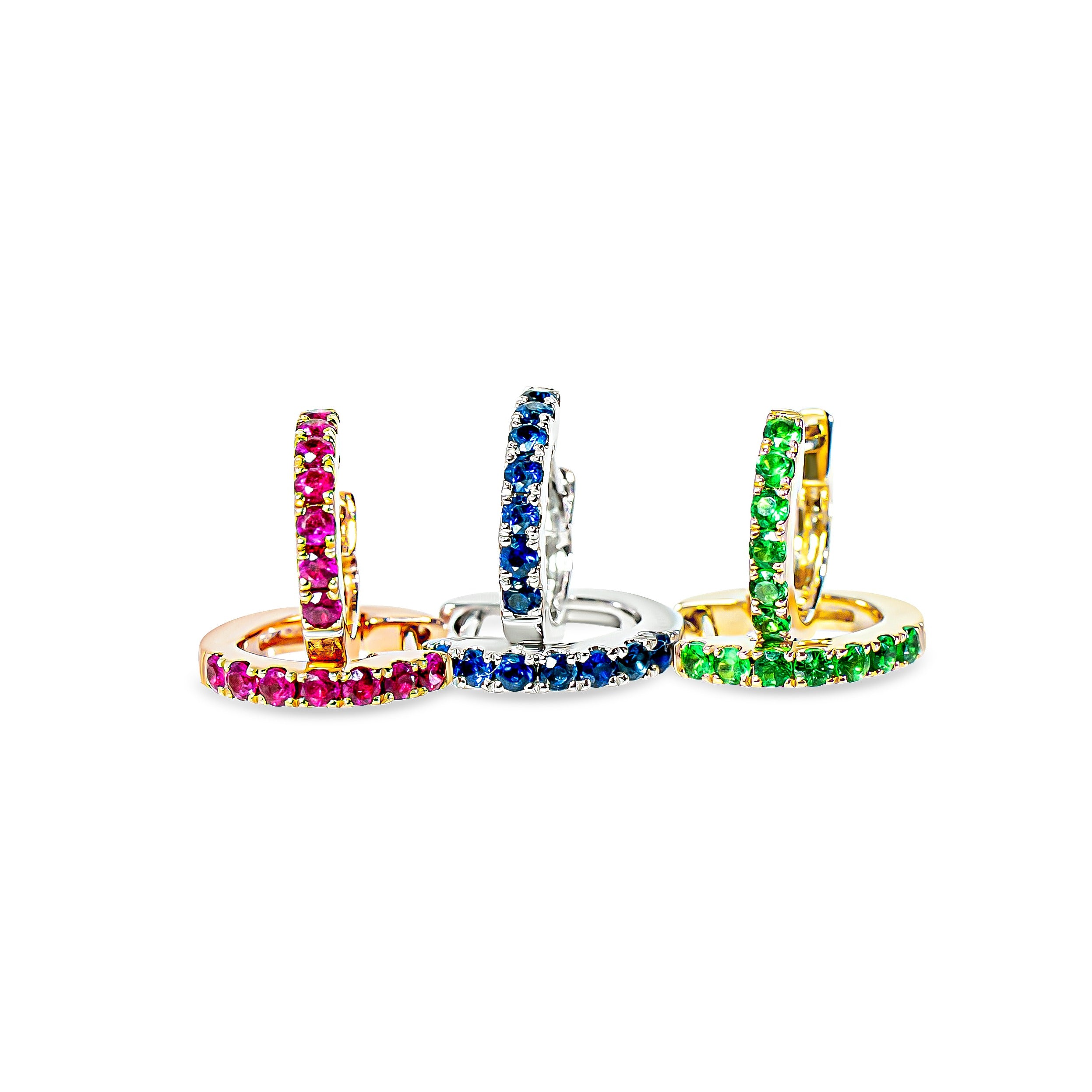 Three hoop earrings with colorful gemstones on a white background