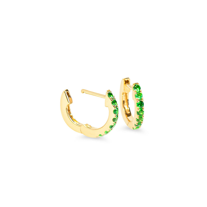 Gold huggie hoop earrings with green tsavorite garnet on a white background