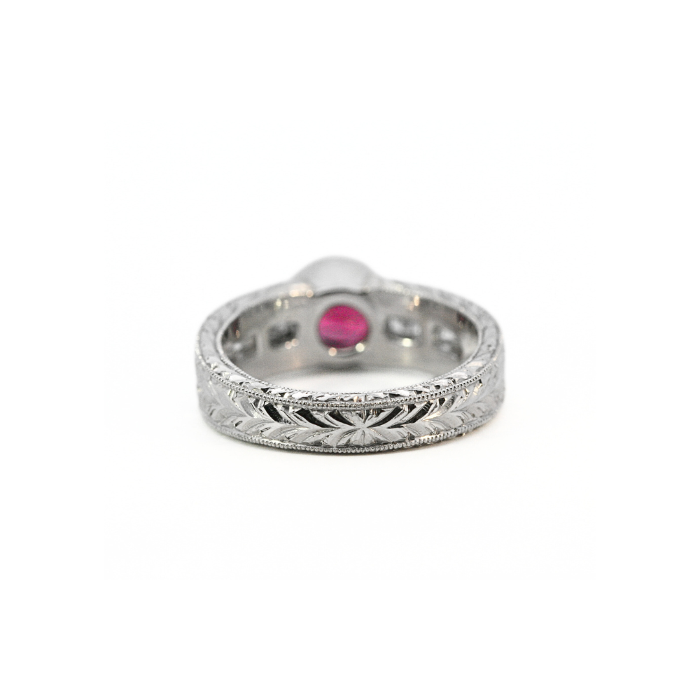 Platinum ring with a red spinel and diamonds on a white background