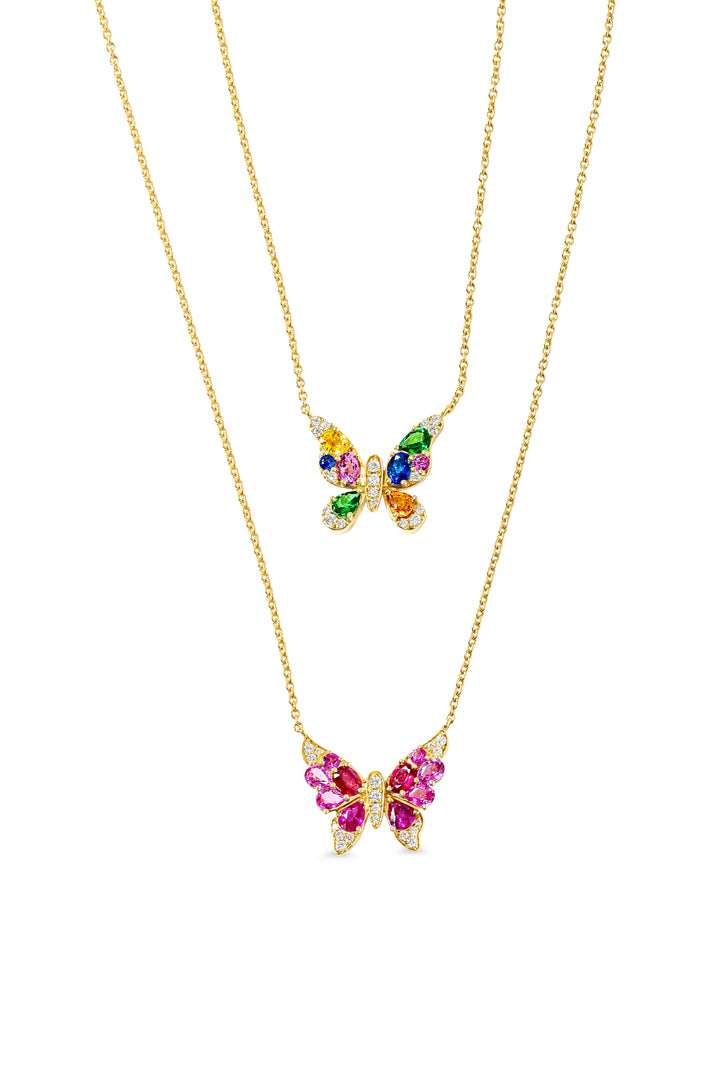 Butterfly-shaped necklaces with colorful gemstones on gold chains against a white background