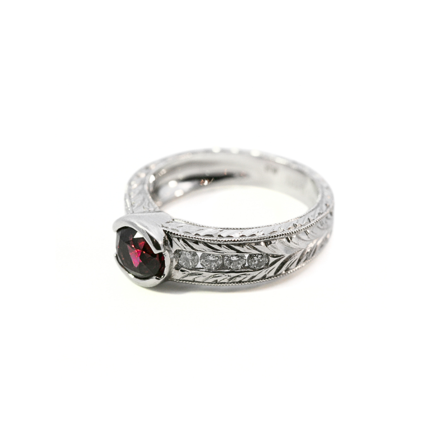 Platinum ring with a red spinel and small diamonds on a white background