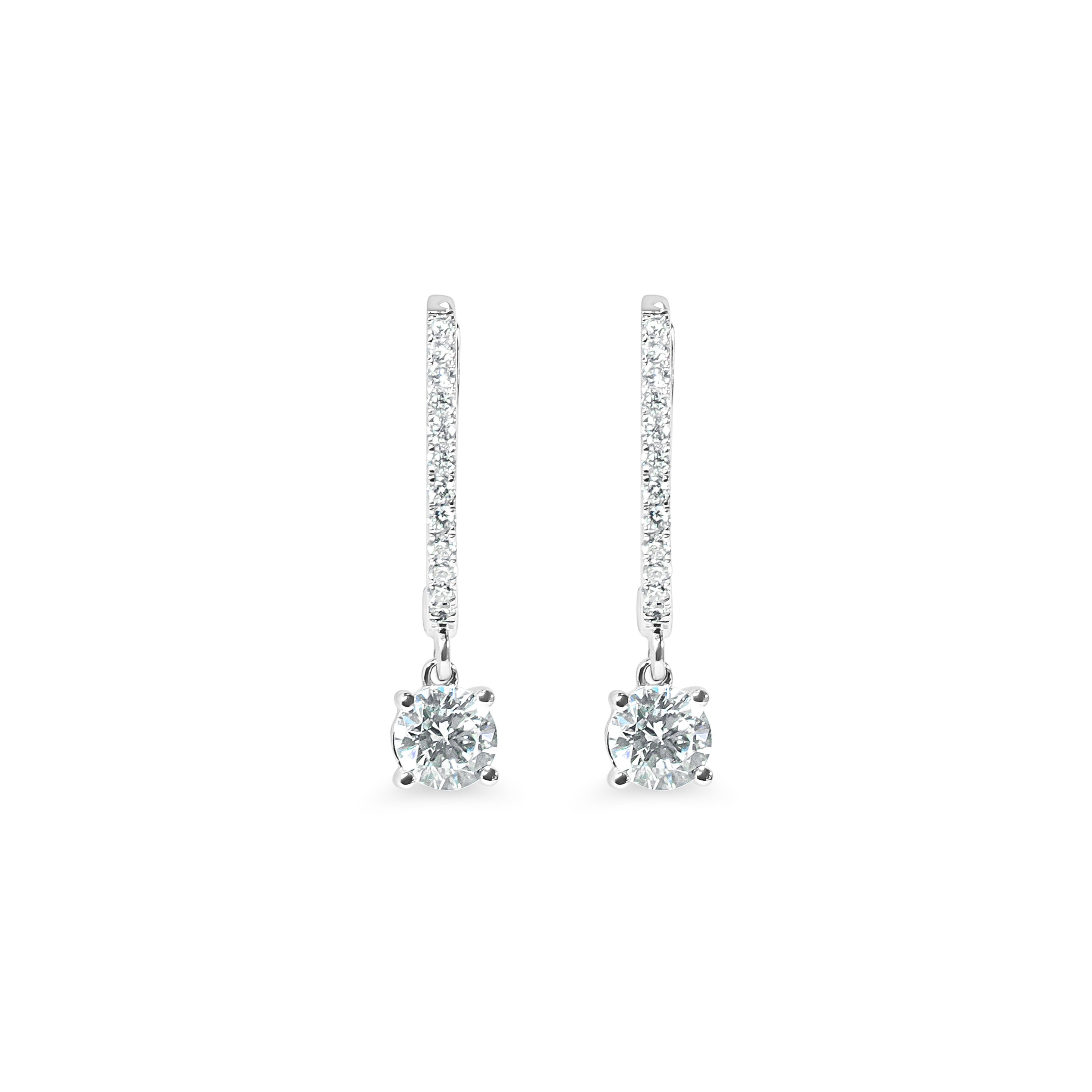 Pair of diamond huggie earrings on a white background