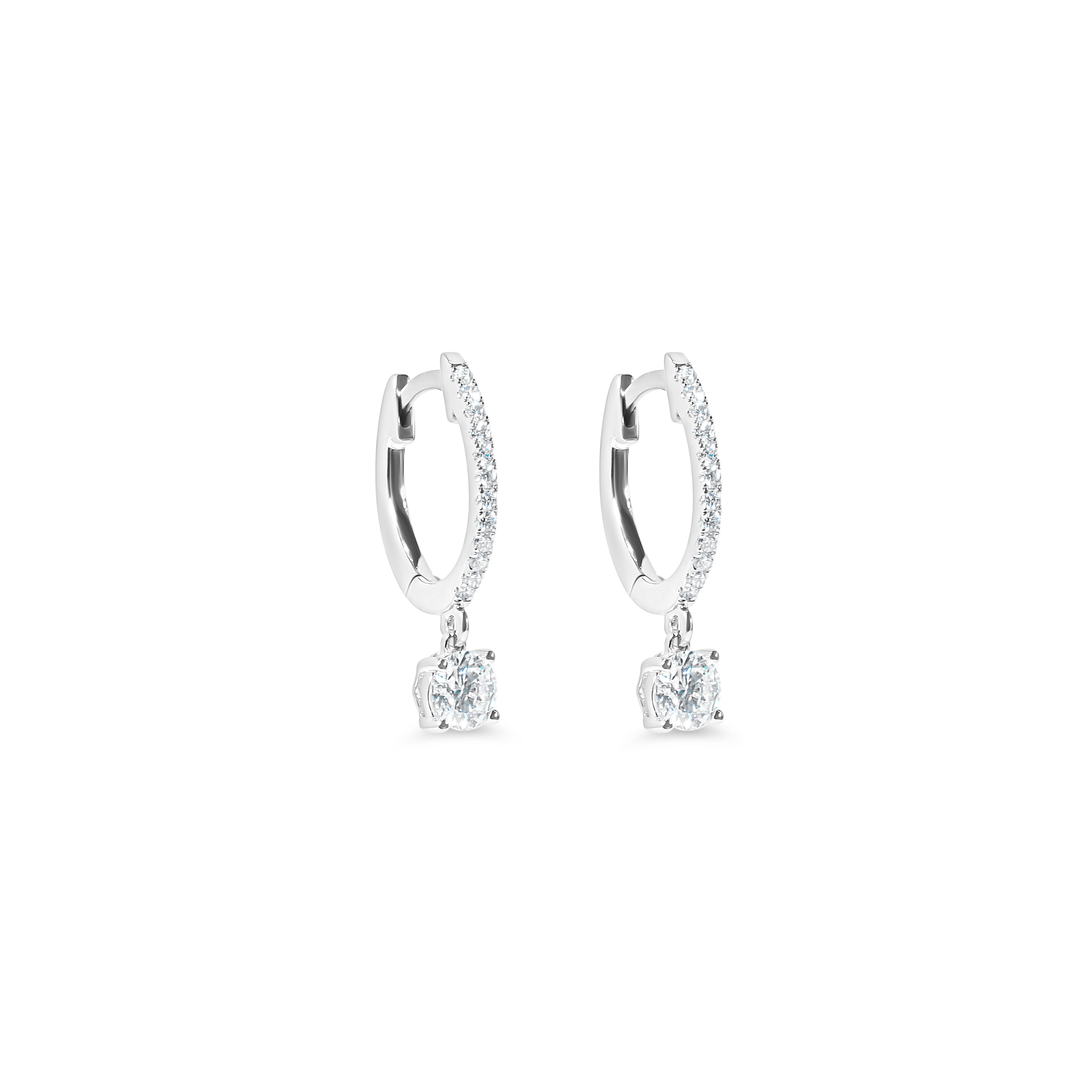 Pair of diamond huggie earrings on a white background
